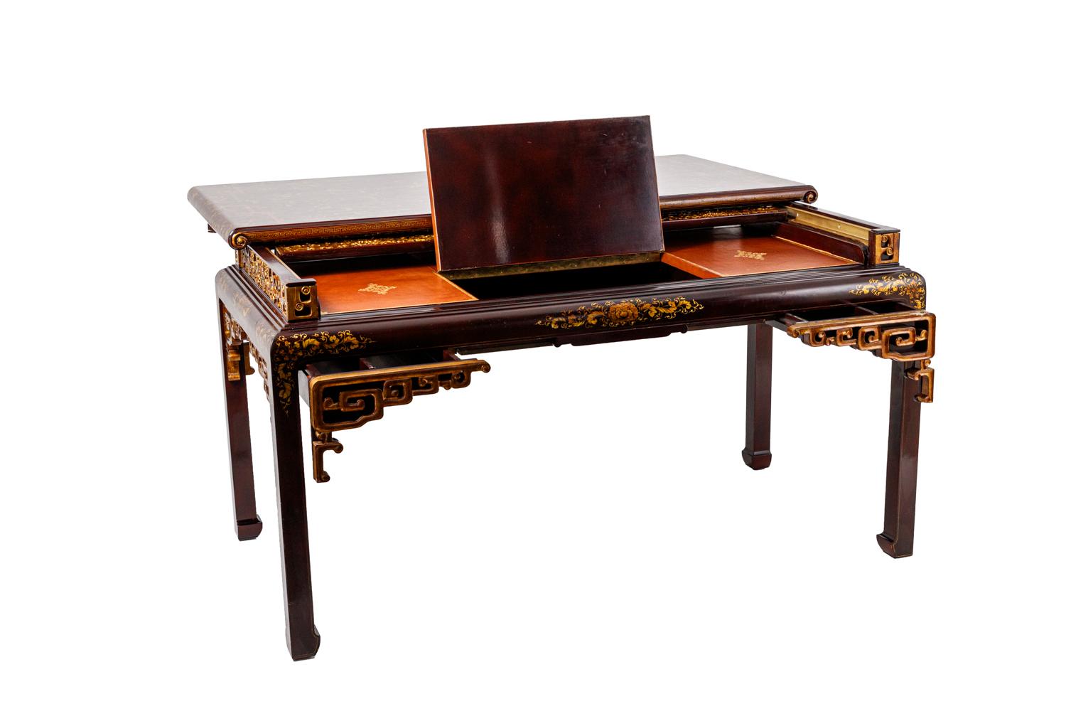 Chinese style desk in red lacquered and giltwood standing on four straight legs. Decor of stylized vegetal motifs on the tray and on the angles of the legs. Sliding tray opening on a secretary in red leather highlighted with gold with a tray opening