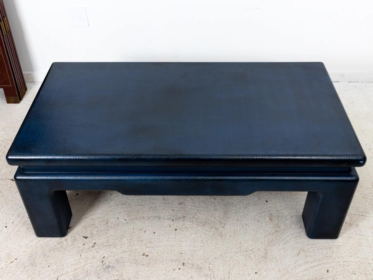 Navy blue painted grass cloth wrapped coffee table in exaggerated Chinese form. Please note of wear consistent with age.