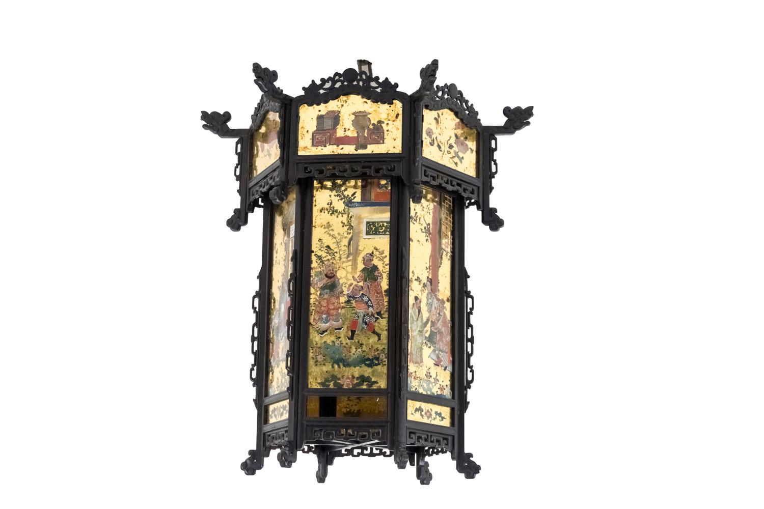 Chinese style lantern in sculpted wood and églomisé glass in hexagon shape standing on six small foot in sculpted wood with ruyi motifs clouds.
Wood blackened structure with Chinese geometrical openwork and sculpted motifs figuring ruyi clouds,