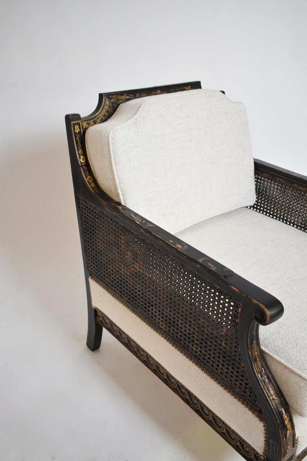 Poltrona in legno dipinta con scene animate policrome e fiori dorati su uno sfondo laccato nero. Schienale e braccioli con canne. Zampe di leone. Nello stile del Giappone e della Cina. Periodo di Napoleone III. Francia, XIX secolo.
