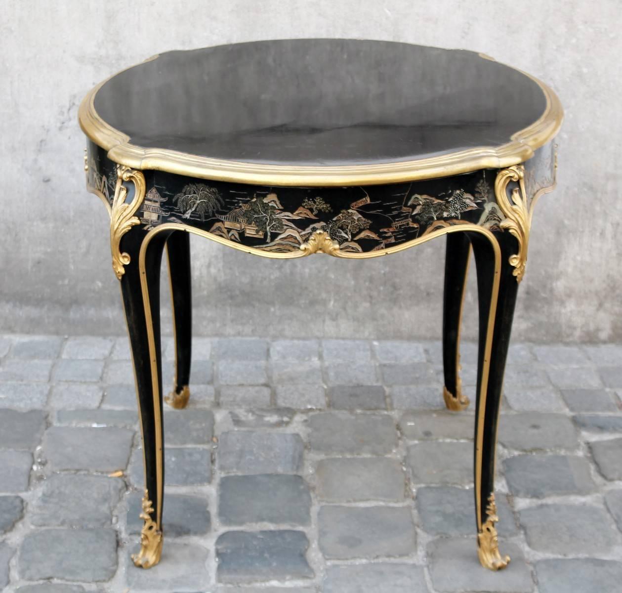 Chinese style stamped table, Rosel, Antwerp, circa 1900.

Mix between Chinese style and Louis XV. The general structure look like Louis XV with the curved feet and the brass to outline the structure. Chinese pattern and the black lacquered wood