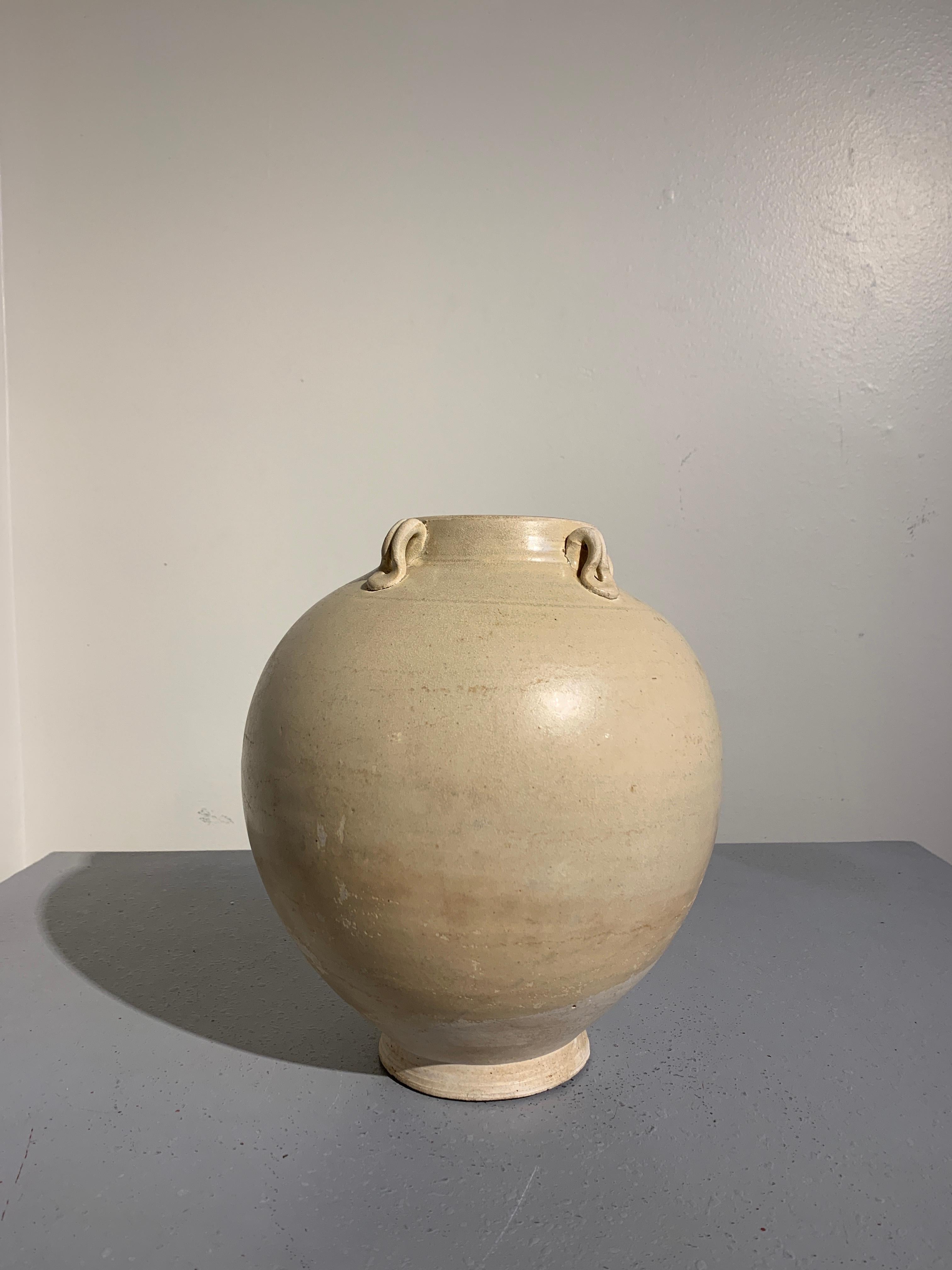 A simple and elegant Chinese high fired white glazed jar with four lug handles, Sui Dynasty (581 to 618), probably Heibei Province. 

The voluptuous jar crafted from a high fired stoneware and glazed a creamy white with a fine crackled surface.