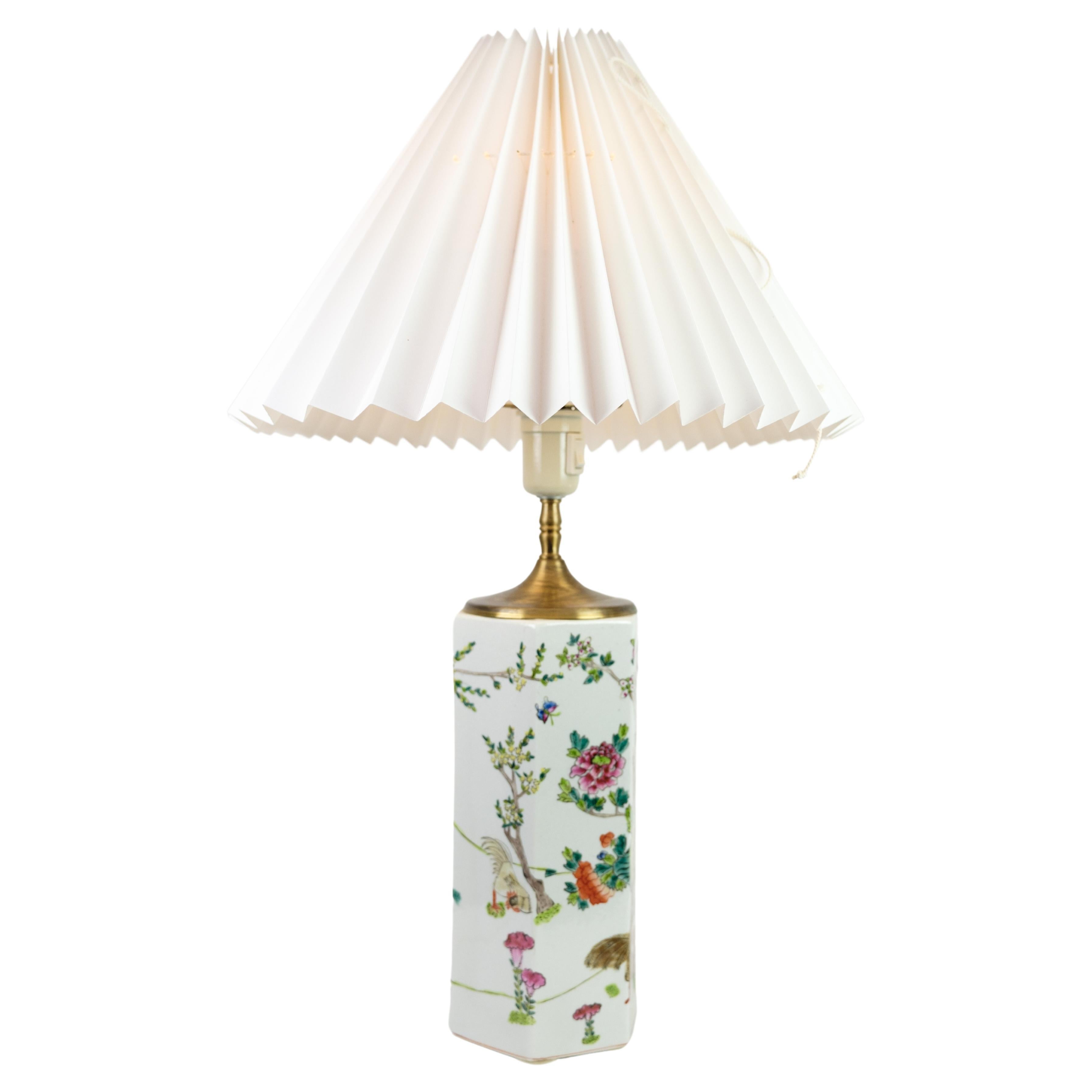 This Chinese table lamp, crafted from porcelain and adorned with motifs of nature, dates back to the 1920s. It stands as an exquisite example of vintage craftsmanship, boasting fine used condition and accompanied by a similar white screen.

The