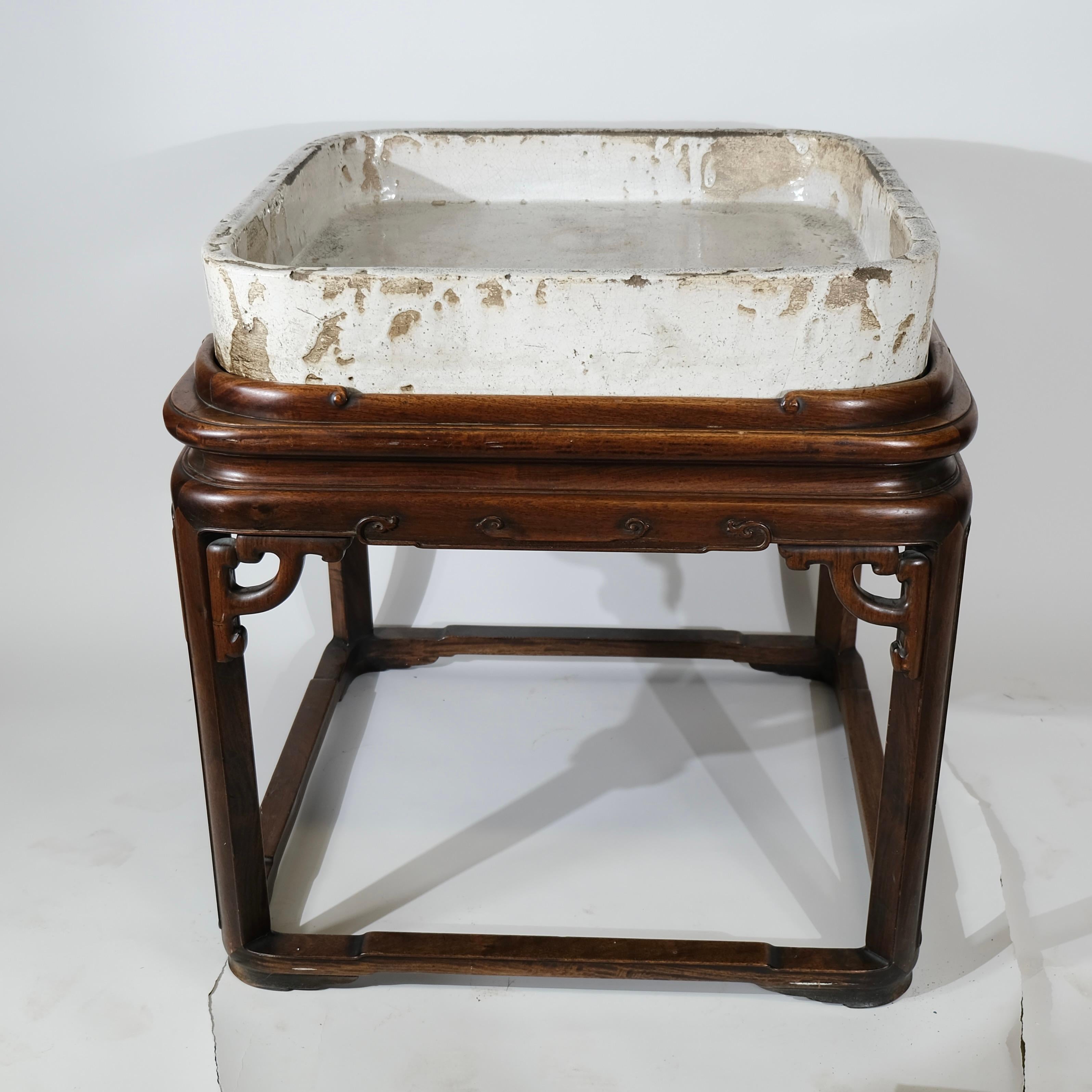 This rose wood table has a built-in basin specifically designed to house live fish. The glazed clay basin would serve as the fish tank, providing a safe and visually appealing environment for the fish. Normally Carp fish.

Alternatively, the table
