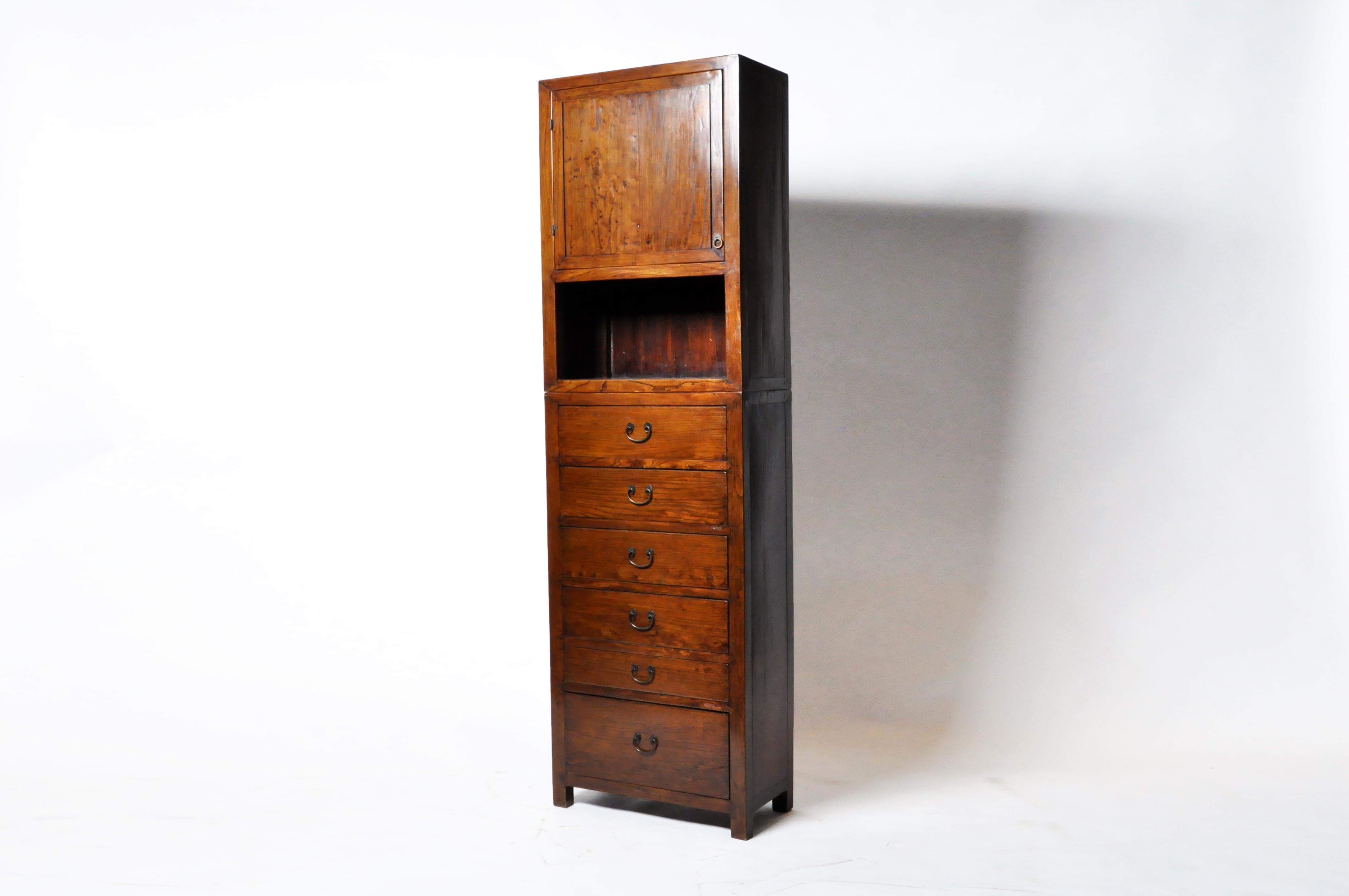 This contemporary piece of furniture features reclaimed elm wood with traditional nail-less joinery and a rich French polish finish. The piece is quite sturdy and heavy given its slim footprint. The drawers feature modern ball-bearing full-extension