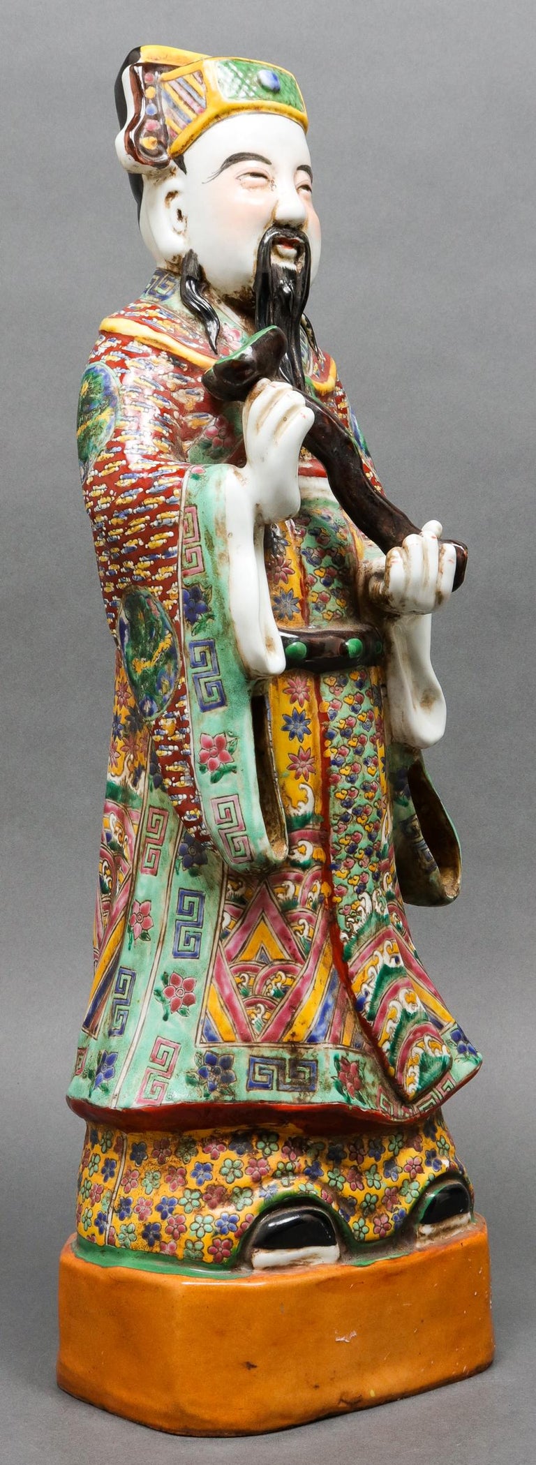 Chinese polychrome glazed ceramic figural sculpture of the immortal Lu, god of wealth, his robe elaborately decorated, stamped to underside. Measures: 22