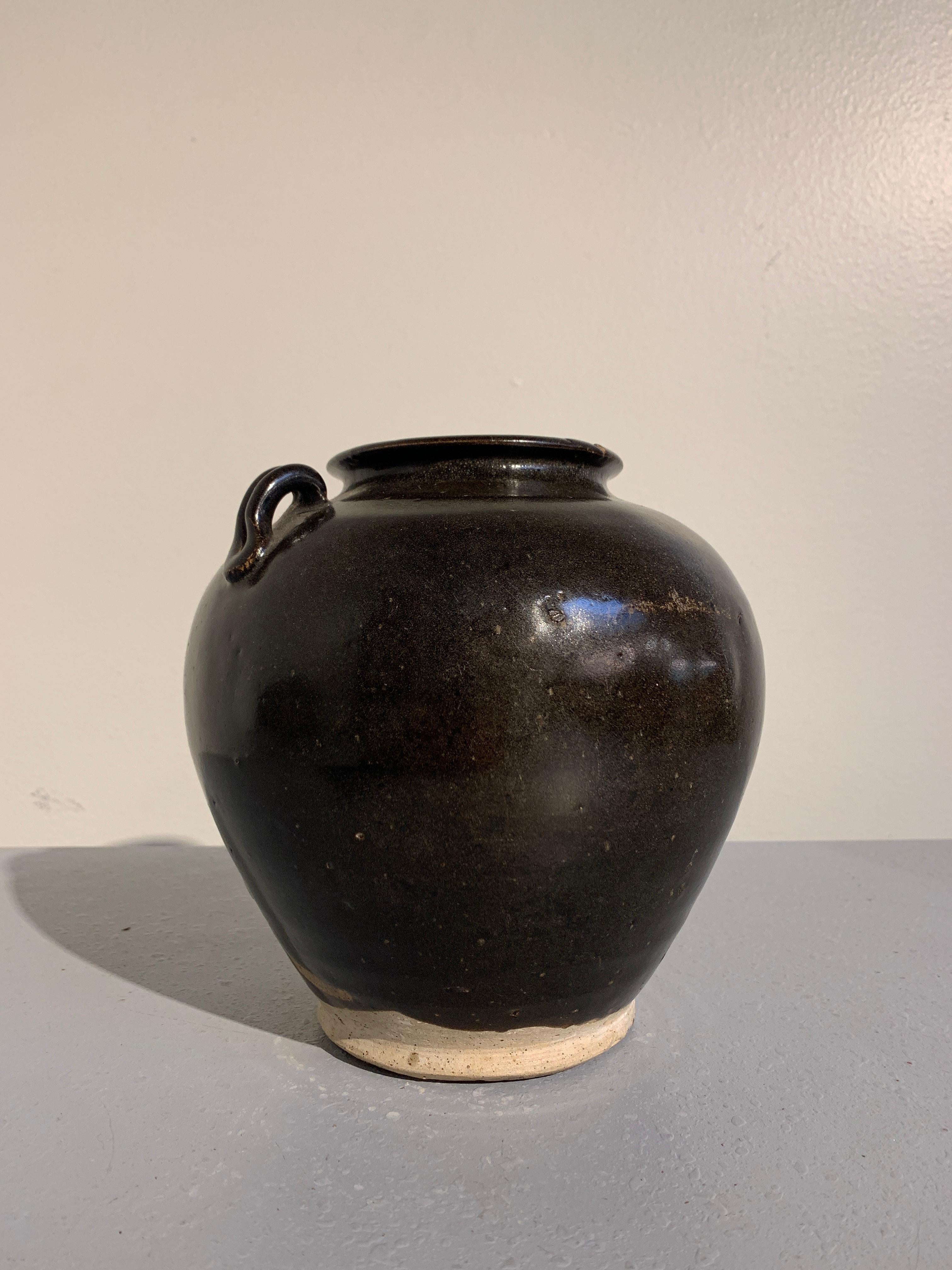 A fine Tang dynasty (618 to 906 AD) brown glazed jar with applied lug handles, circa late 9th or early 10th century, China. 

The jar of somewhat stout proportions, but sill elegantly shaped, with a flat foot and tapered waist rising to broad,
