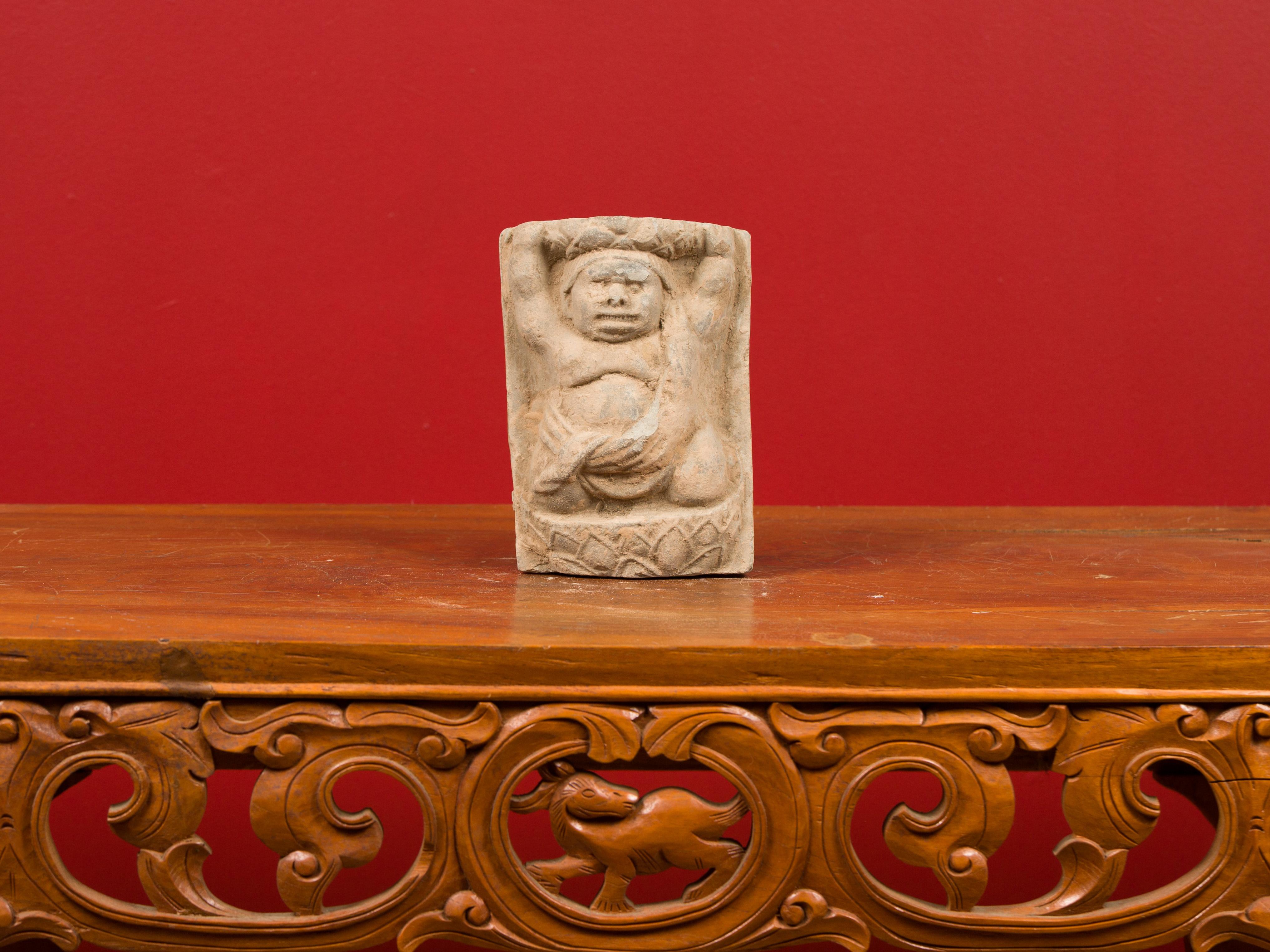 A small Chinese Tang Dynasty carved stone wall plaque circa 618-907 AD with frontal figure. Crafted in China during the Tang Dynasty, this carved stone wall plaque depicts a male figure depicted in a frontal position, his arms raised. Wearing a