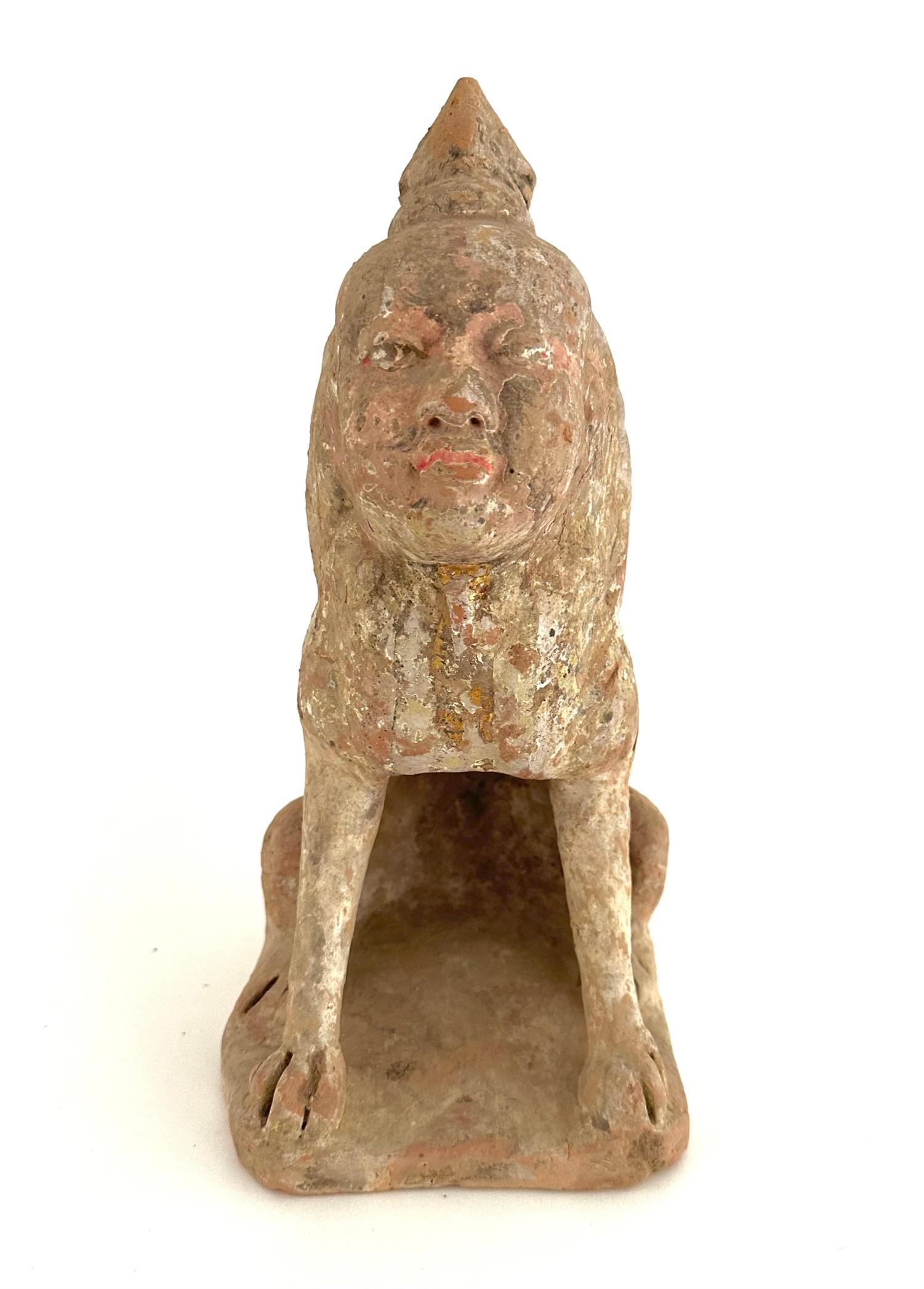 This beautiful Tang dynasty earth spirit with human face and animal body is crafted with terracotta and paint.
This semi-human spirit figure is seated on its haunches with cloven hooves planted firmly on the base. Wearing conical mandarin style
