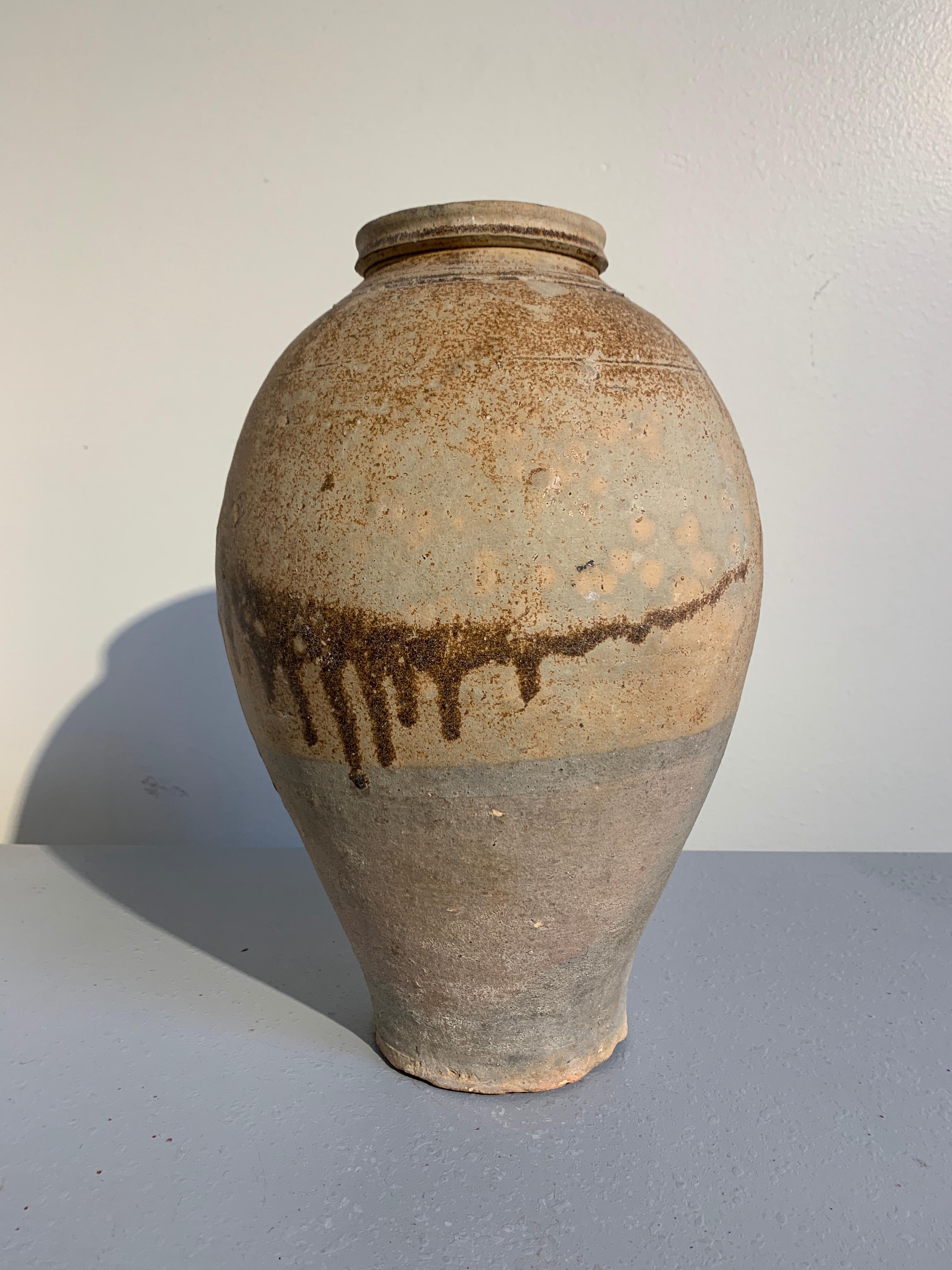 A quiet and surprisingly contemporary looking Tang Dynasty (618 to 906 AD) ovoid jar with an abstract drip glaze, China, circa 8th century. 

The tall, slender vase of elegant proportions, with a voluptuous body tapering upwards from a flat foot