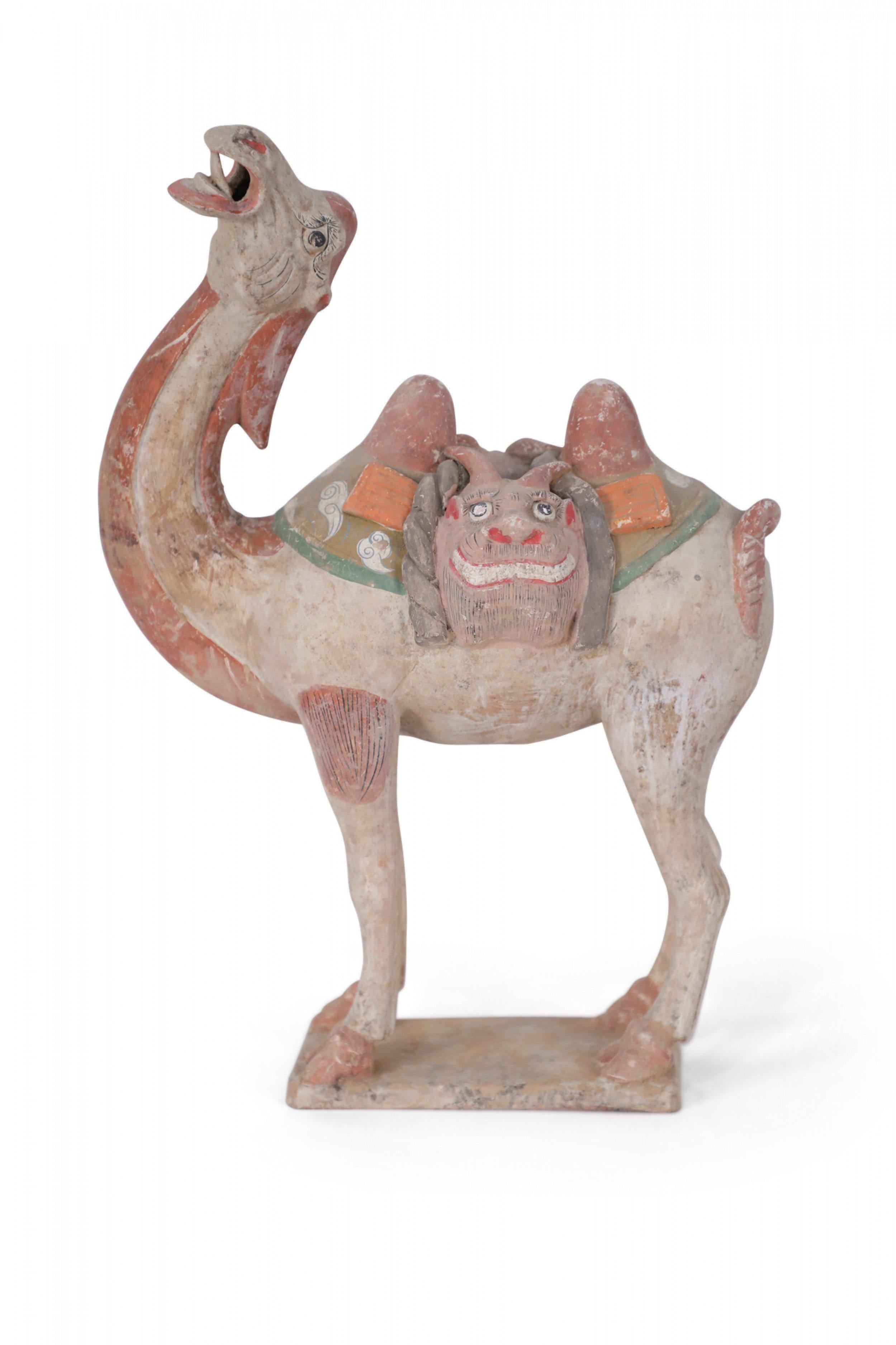 Antica figura tombale in terracotta in stile Tang Dynasty cinese di un cammello bactriano, il principale mezzo di trasporto sulla Via della Seta, con la testa inclinata all'indietro e la bocca aperta verso il cielo, che indossa una sella che mostra