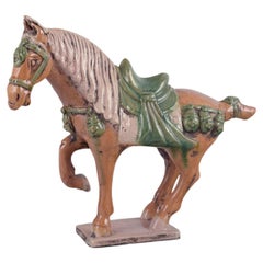 Caballo chino estilo Tang Dynasty en cerámica. Esmaltado en tonos marrones y verdes.