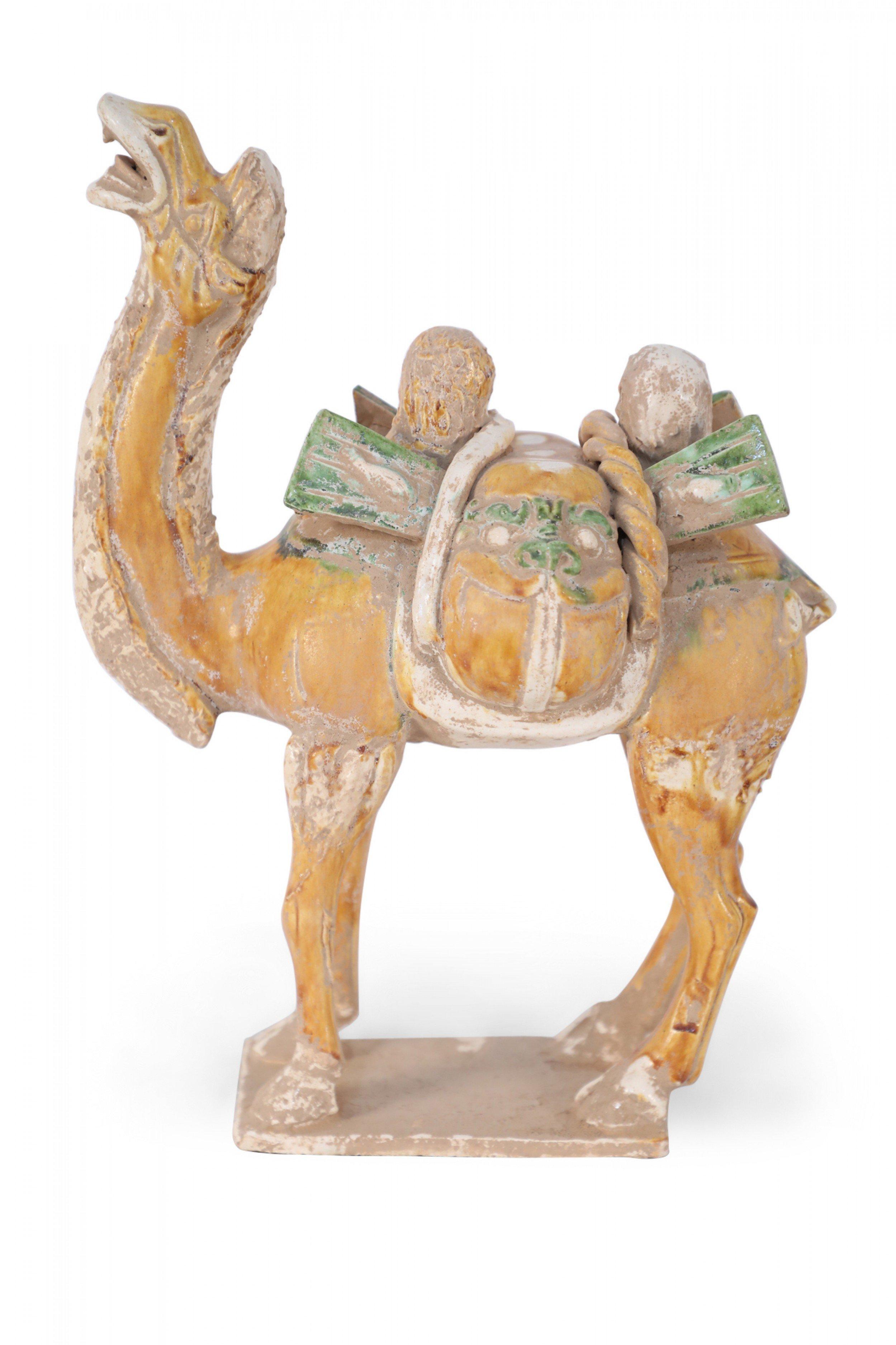 Antique Chinese Tang Dynasty-style terra cotta tomb figure of a Bactrian camel, the main form of transport over the Silk Road, with its head tilted back and mouth open to the sky, wearing a saddle that shows a 