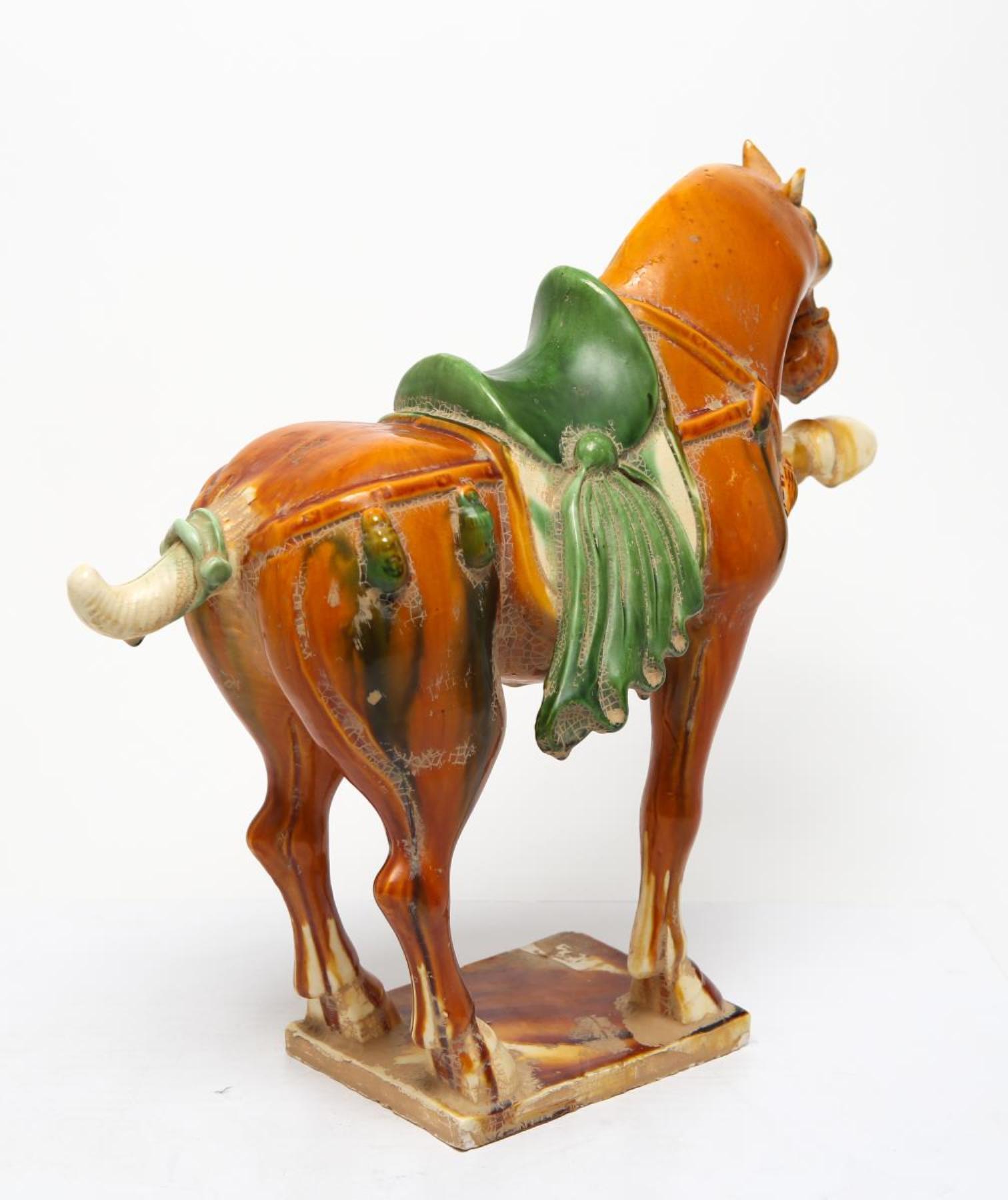 Chinese Tang-manner horse sculpture in Sancai-glazed pottery, with left front leg raised. Repairs to raised leg and lacking tip of left ear. In overall great vintage condition.