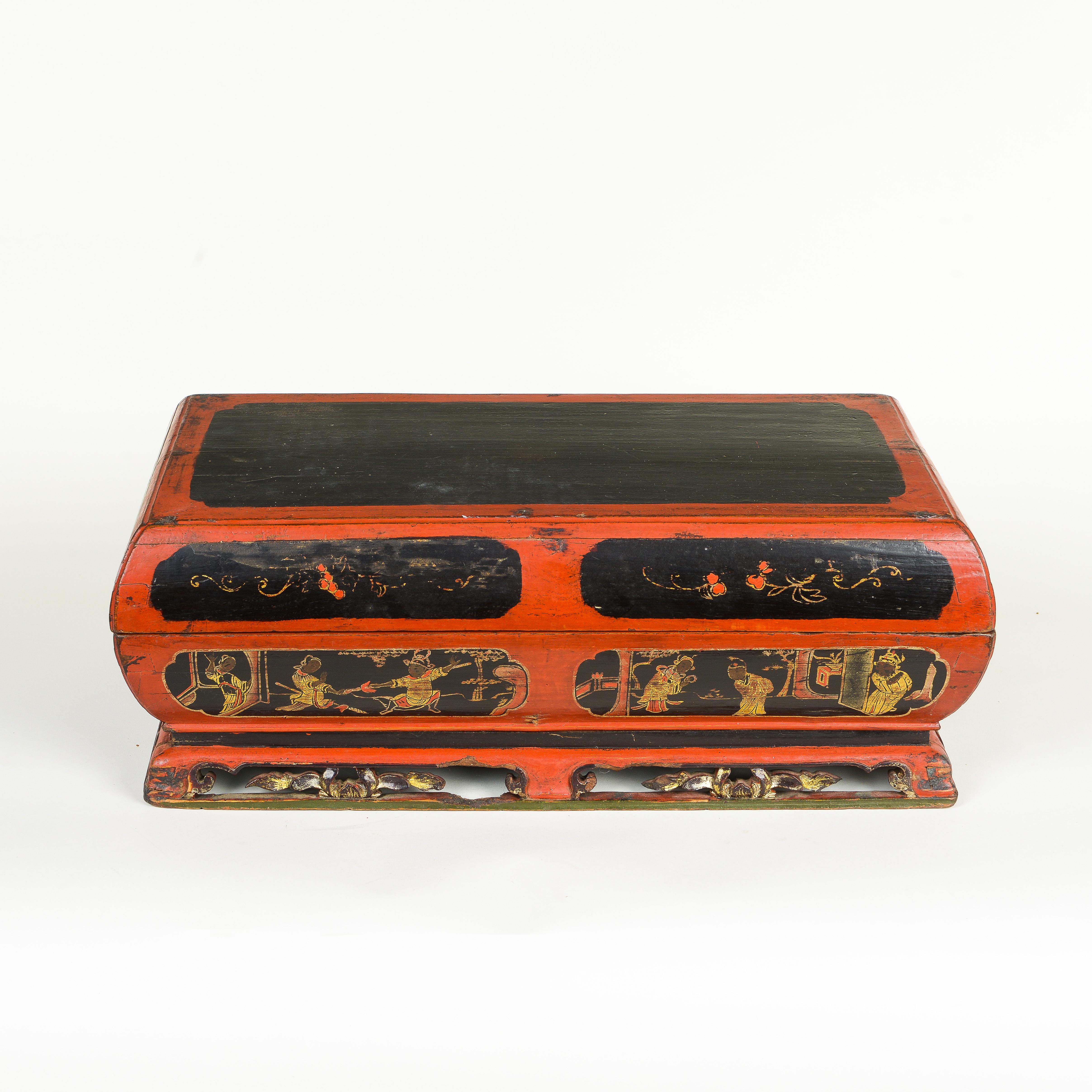 La boîte en bois rectangulaire à couvercle est peinte en noir et rouge avec des cartouches de personnages de la Cour et des décorations florales ; elle s'ouvre pour révéler huit plats.
