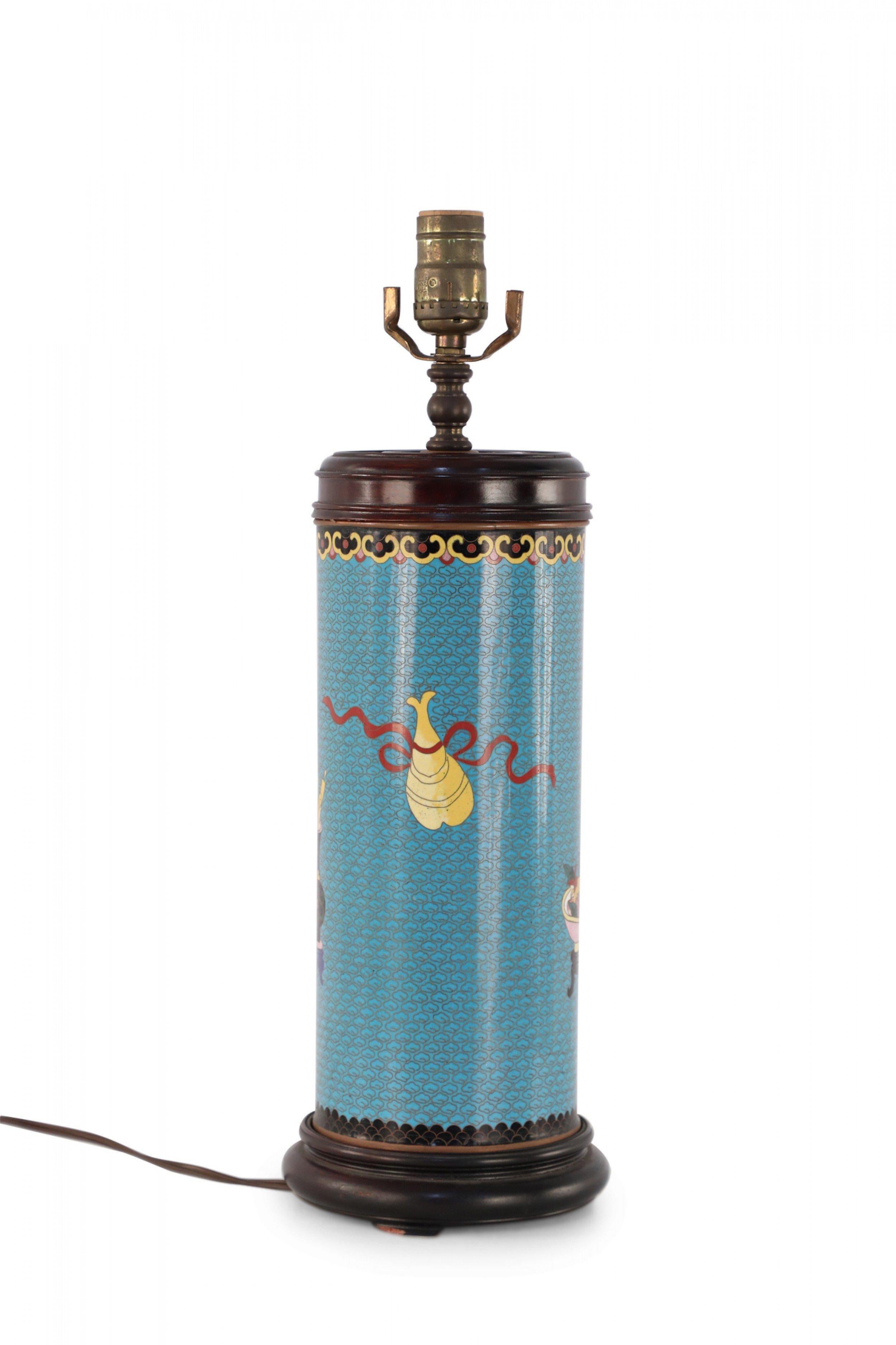 Chinese cylindrical table lamp made from a teal and gold-patterned cloisonne vase painted with floral arrangements and fruit bowls with a brown wooden base and top and brass hardware.
 