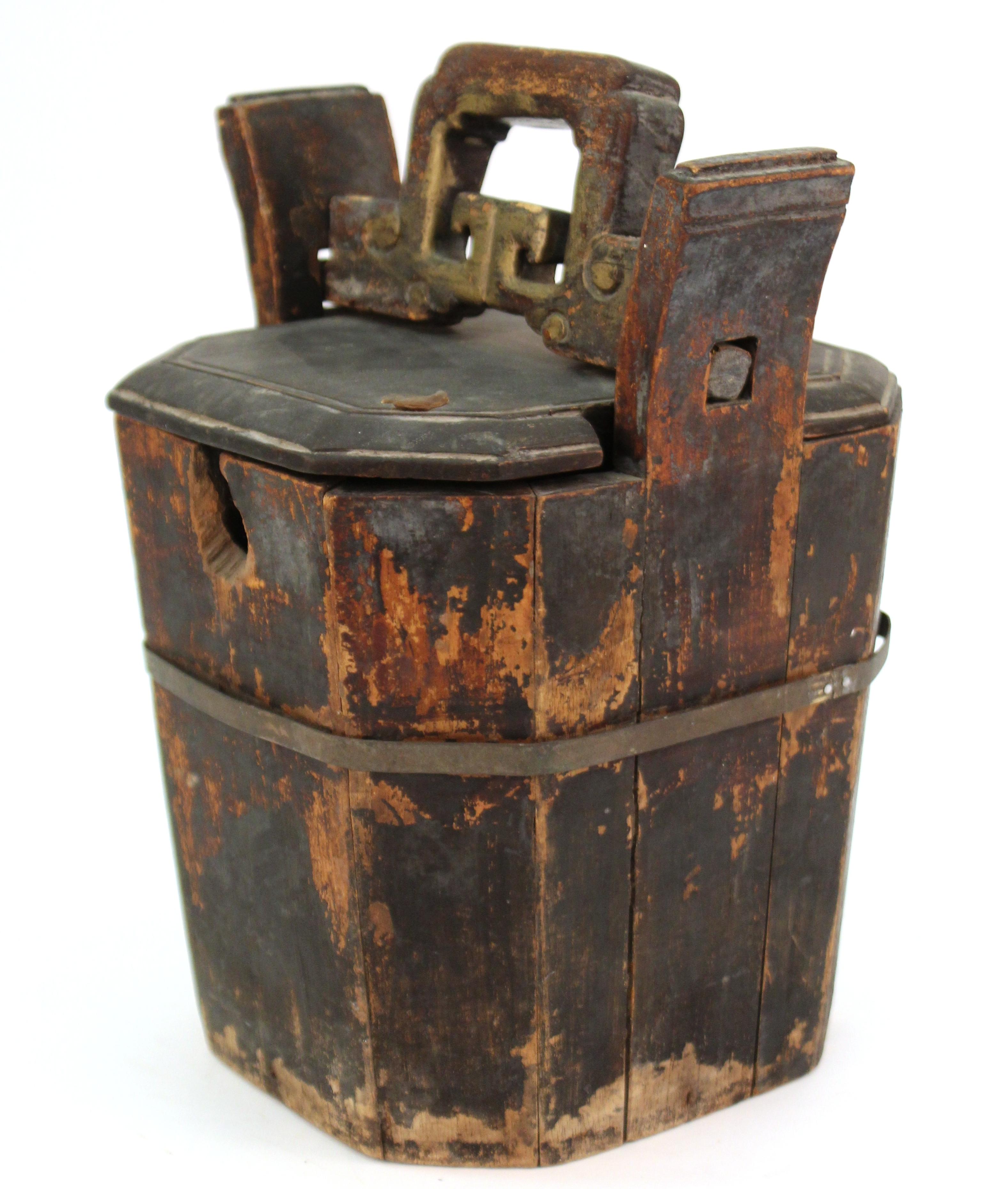 Chinese carved wood teapot caddy. The front panel has a hole opening for the spout, with a shaped wood carrying handle inserted into the ears, the lid having a partial Jian Ding wax seal from the 19th century.
Wear and losses to the gilt-painted