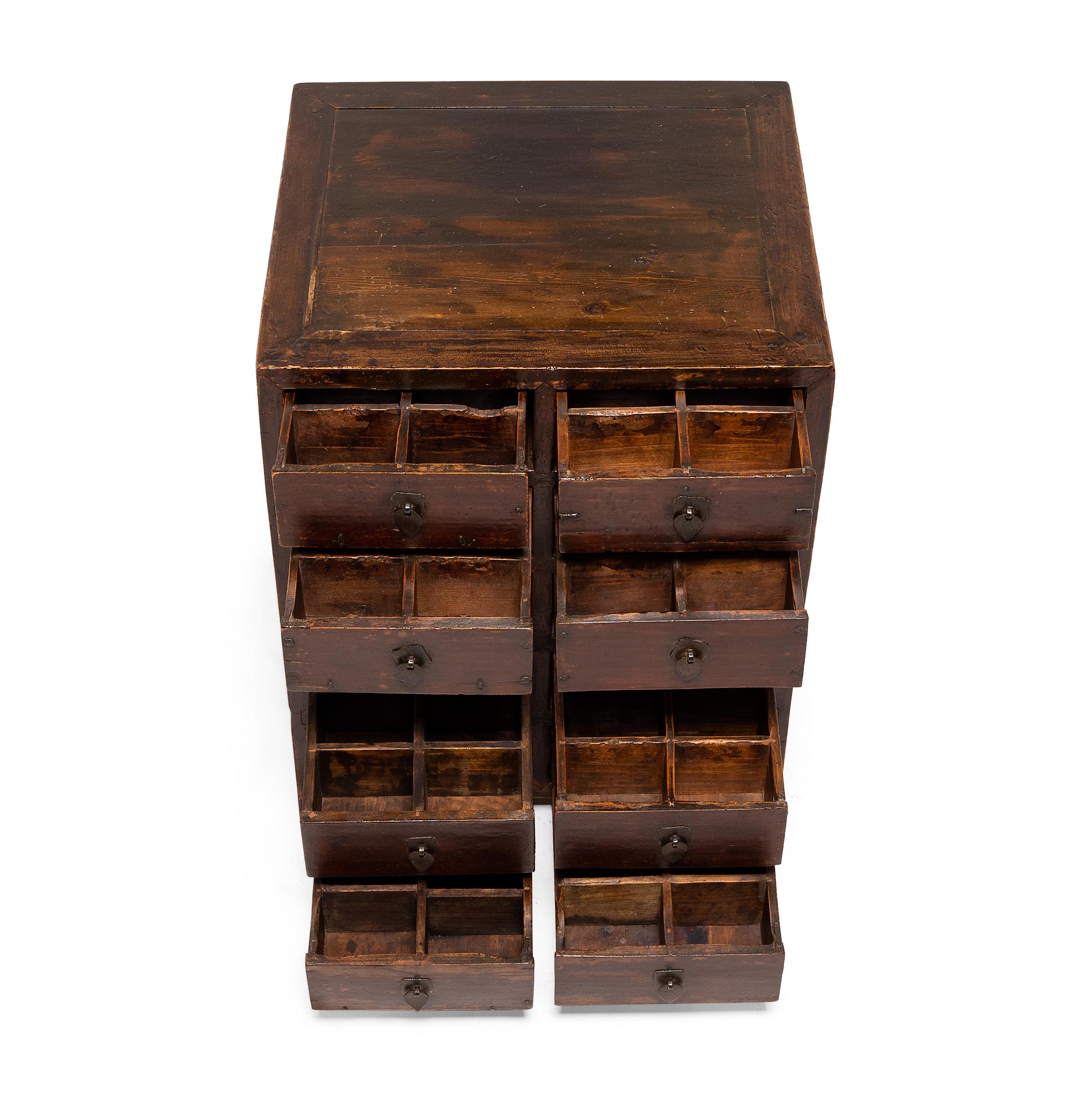 This petite lacquered chest of drawers was originally used in a 19th-century Chinese pharmacy to organize and store herbal medicines. The square-corner cabinet is constructed with ten shallow drawers, each divided into six small interior