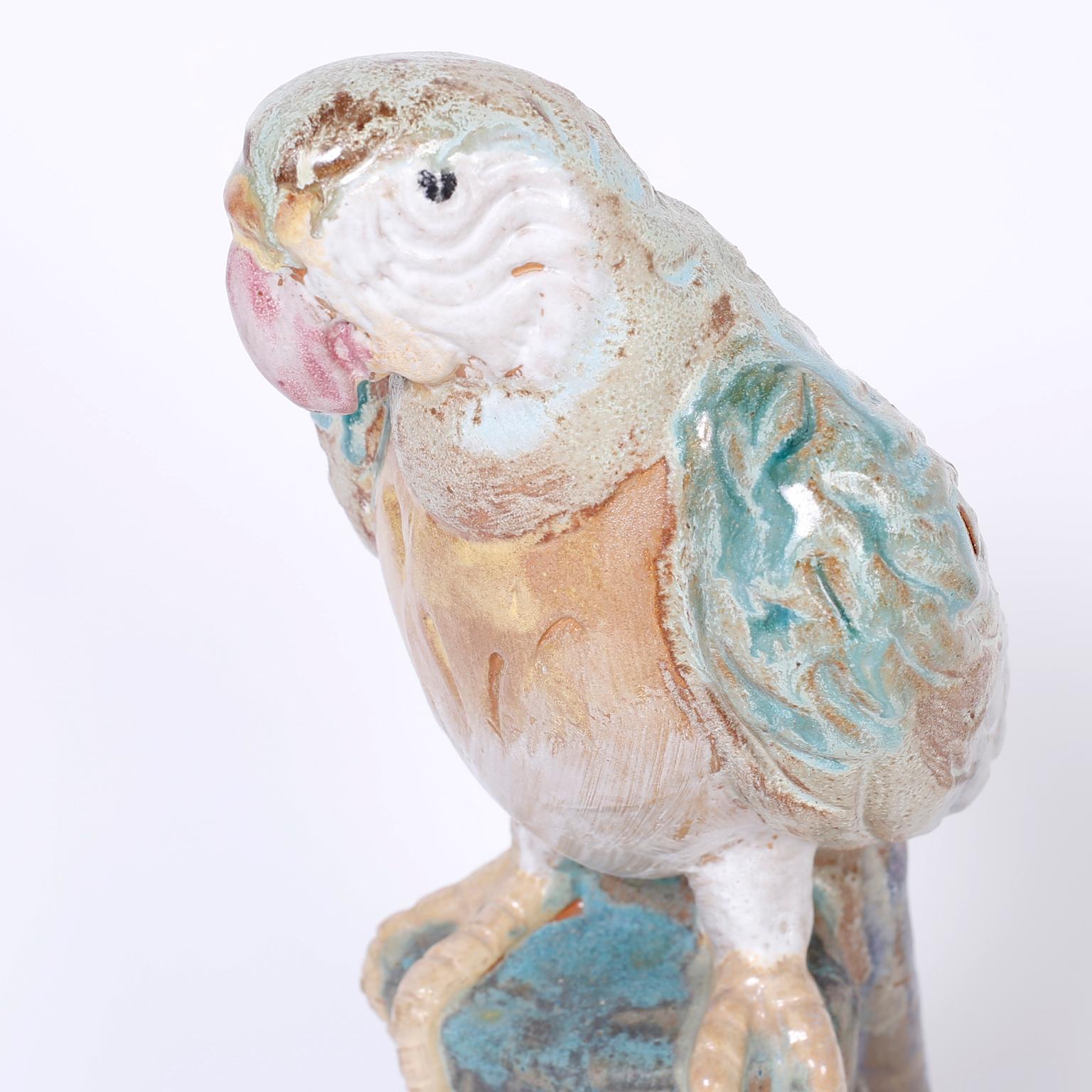 Life-size terracotta parrot or bird with a quizzical expression, decorated and glazed with soft muted colors.
