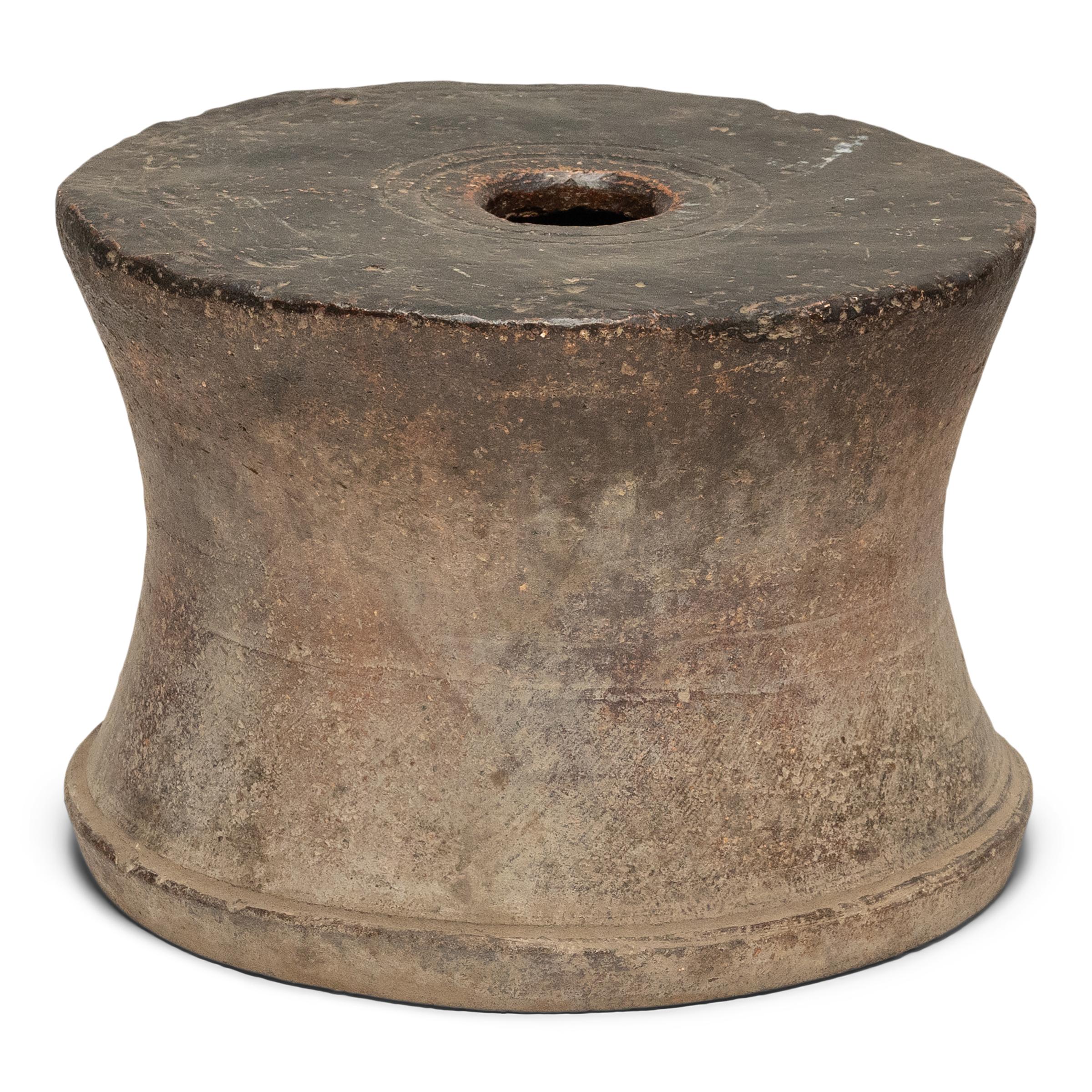 Dated to the mid-19th century, this low, terracotta pedestal base from Shanxi province likely originated as a column base or as the display plinth for a large Buddha statue. The round pedestal has an unusual, spool-like shape, with sides that bow