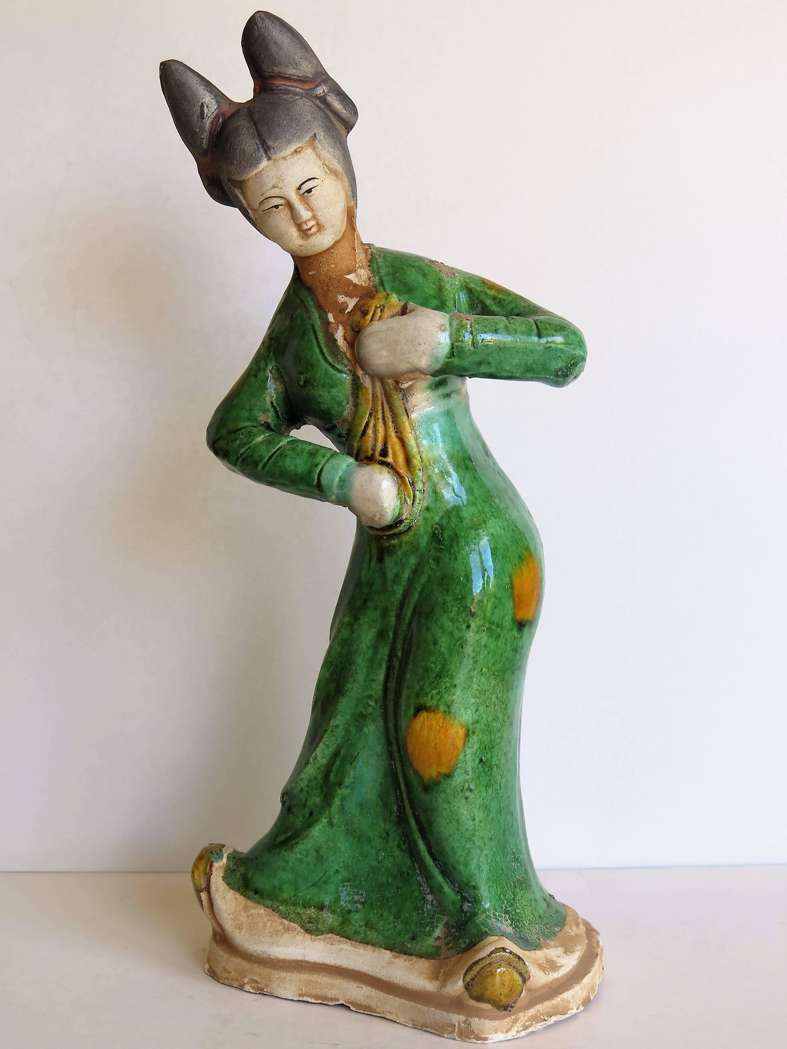 This is a good female Chinese figure or figurine playing a lute, hand sculpted out of terracotta (clay) and hand painted with some glazed polychrome enamels, made in China in the early 19th century Qing dynasty, or earlier, but in the Ming