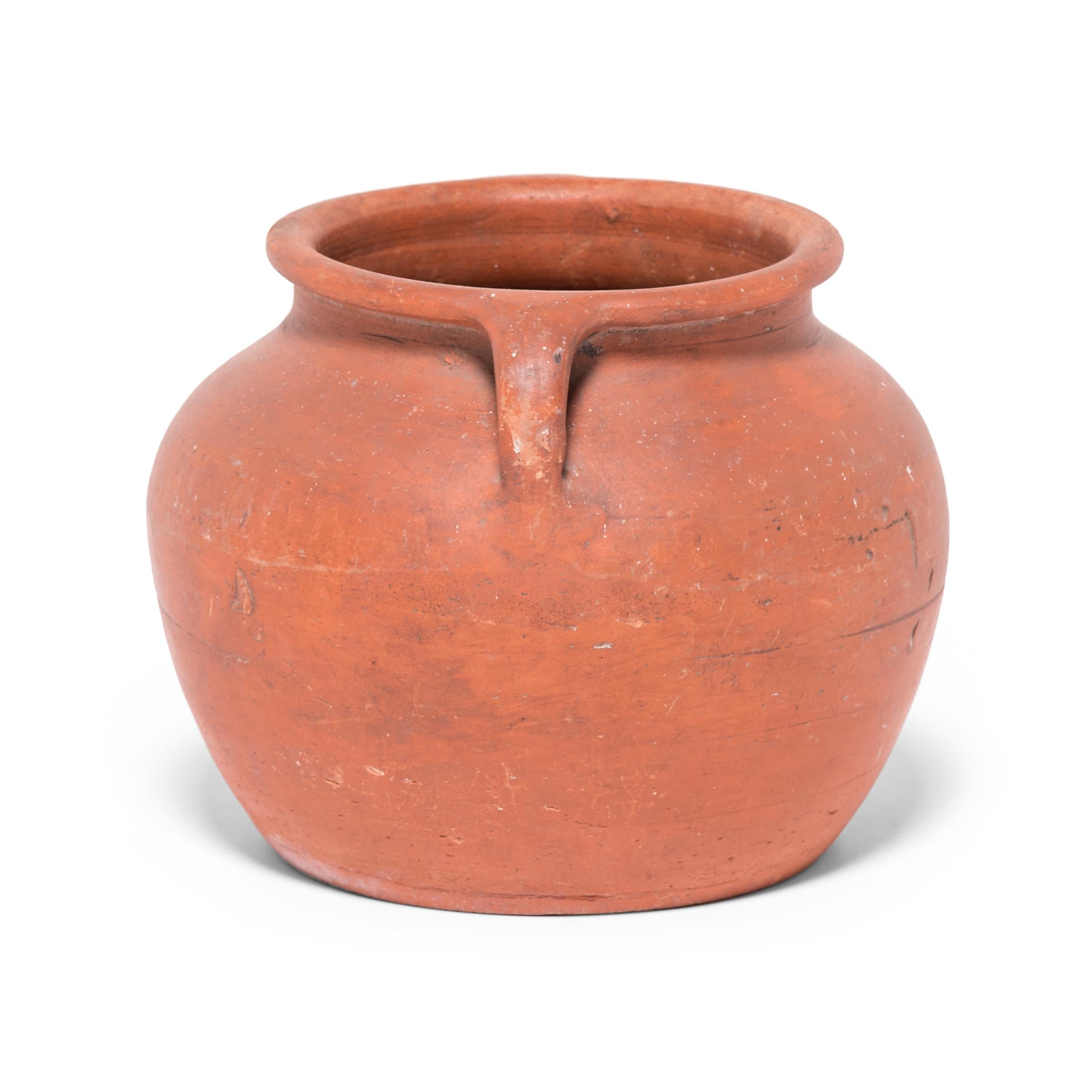 Based on vessels fired in ancient Chinese kilns, this jar's perfect proportions haven't changed much since the bronze age. Keeping in the tradition of its predecessors, this early 20th century ceramic vessel is glazed with a slip of red clay,