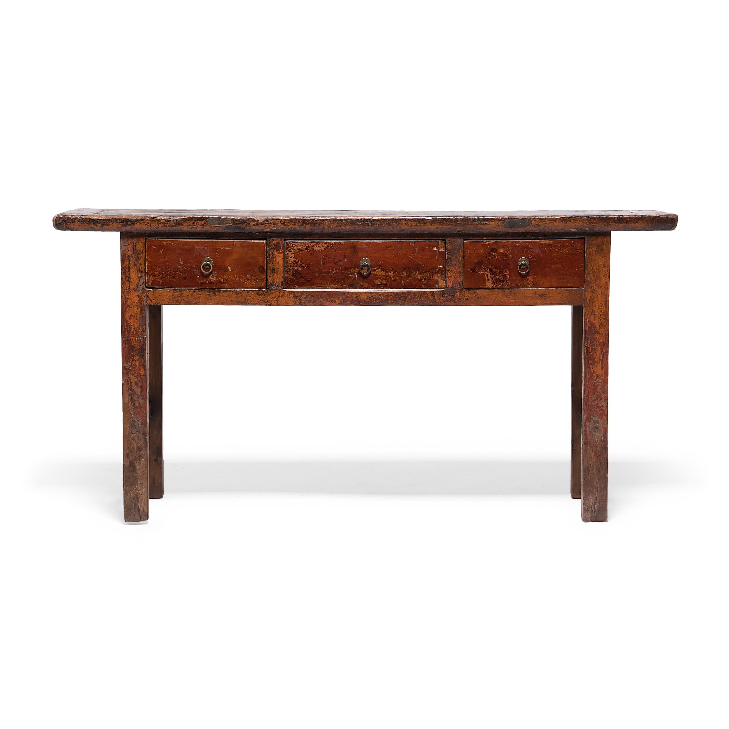 Dated to the early 20th-century, this three-drawer table began its life in China's Gansu province as a versatile surface in a provincial home, used for general household storage and as a domestic altar for ancestor worship. Crafted of poplar, the