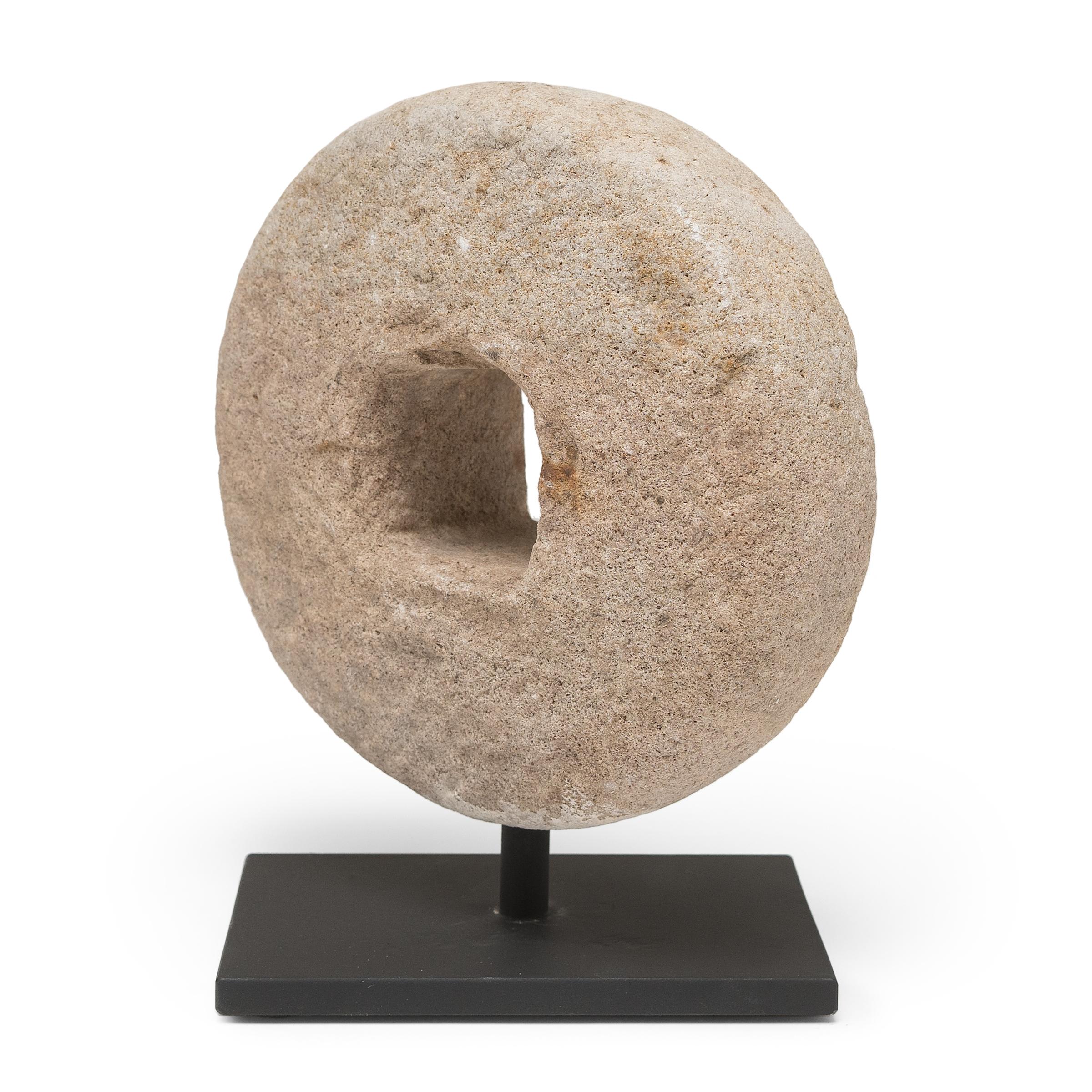 Ce disque rond en pierre était à l'origine une roue de battage du début du XXe siècle. Fixée à un axe en bois qui traversait le centre, la pierre était roulée sur les tiges de blé pour séparer les grains, tirée soit par un homme, soit par un bœuf.