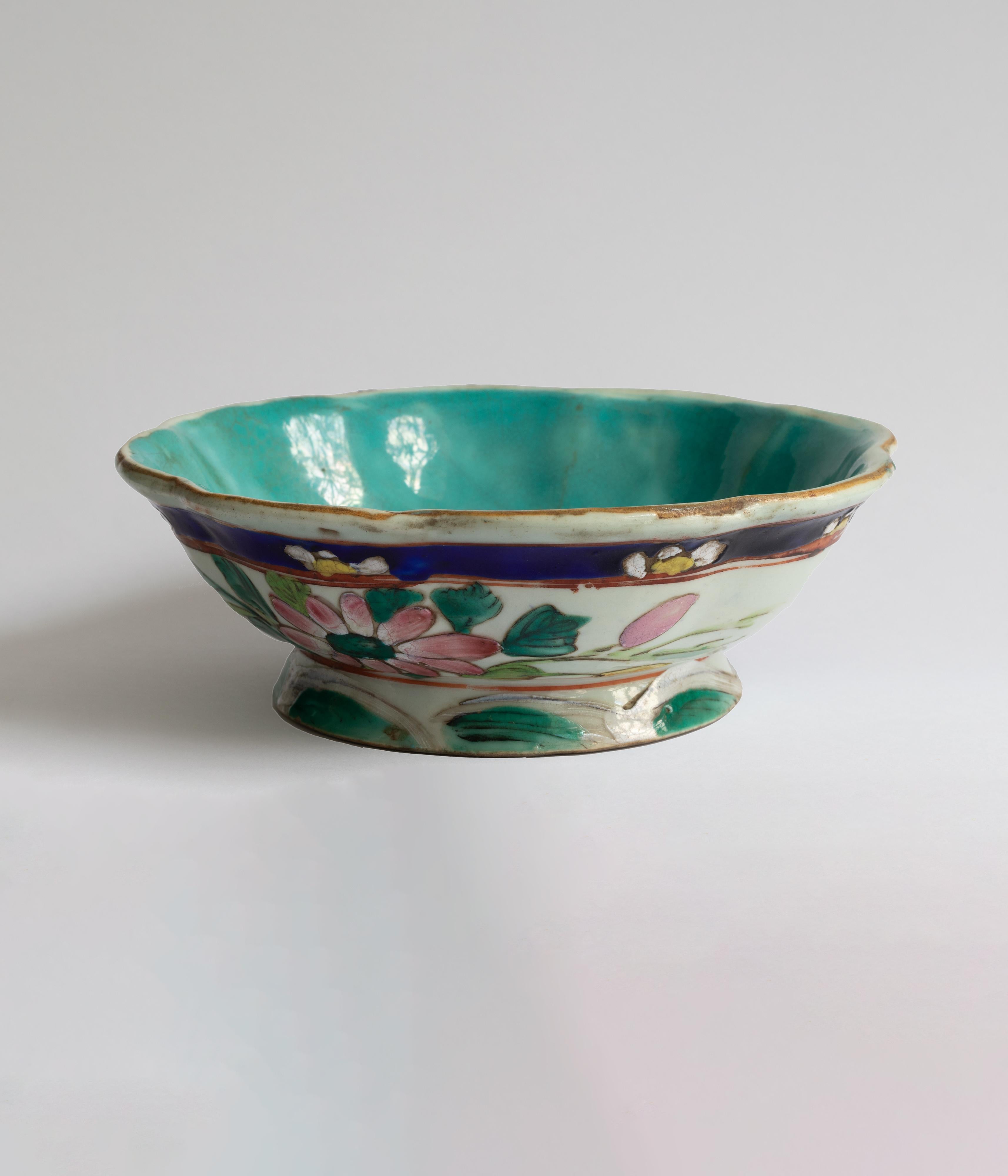 A chinese Tongzhi floral offering bowl from the 19th Century. This porcelain bowl was utilized as a serving vessel for ceremonial tributes, positioned in front of an altar. It is crafted in the shape of an eight-petal flower and exhibits scalloped