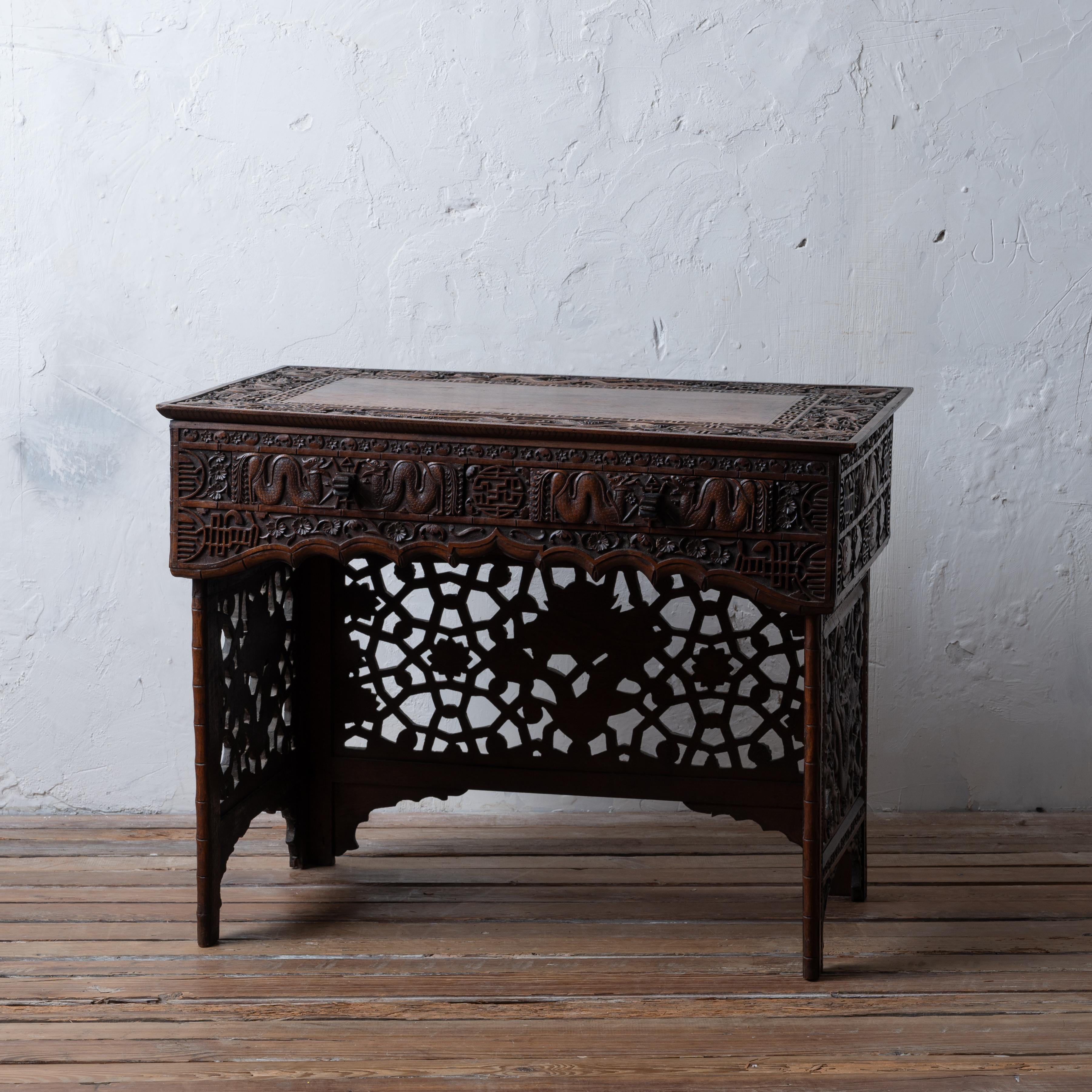 A highly carved Chinese scribe’s folding desk, circa 1900.

of small proportions:
34 inches wide by 21 ½ inches deep by 27 inches tall; 8 ¾ inches tall folded

