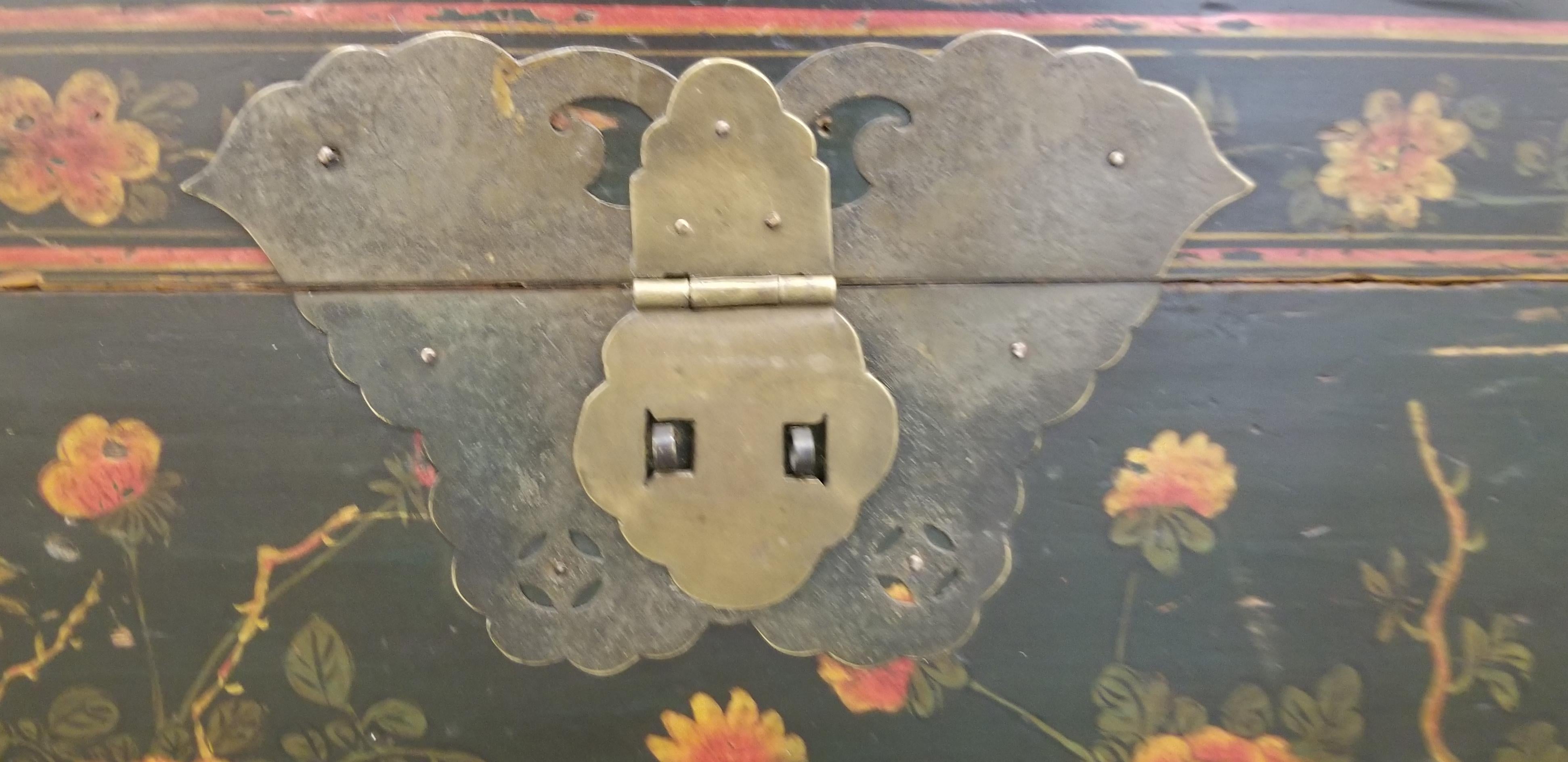 Early 20th century Chinese trunk on stand with butterfly hardware and brass handles. Hand painted floral detail with lovely patina to original finish. Could work well as a side, coffee or end table with storage.