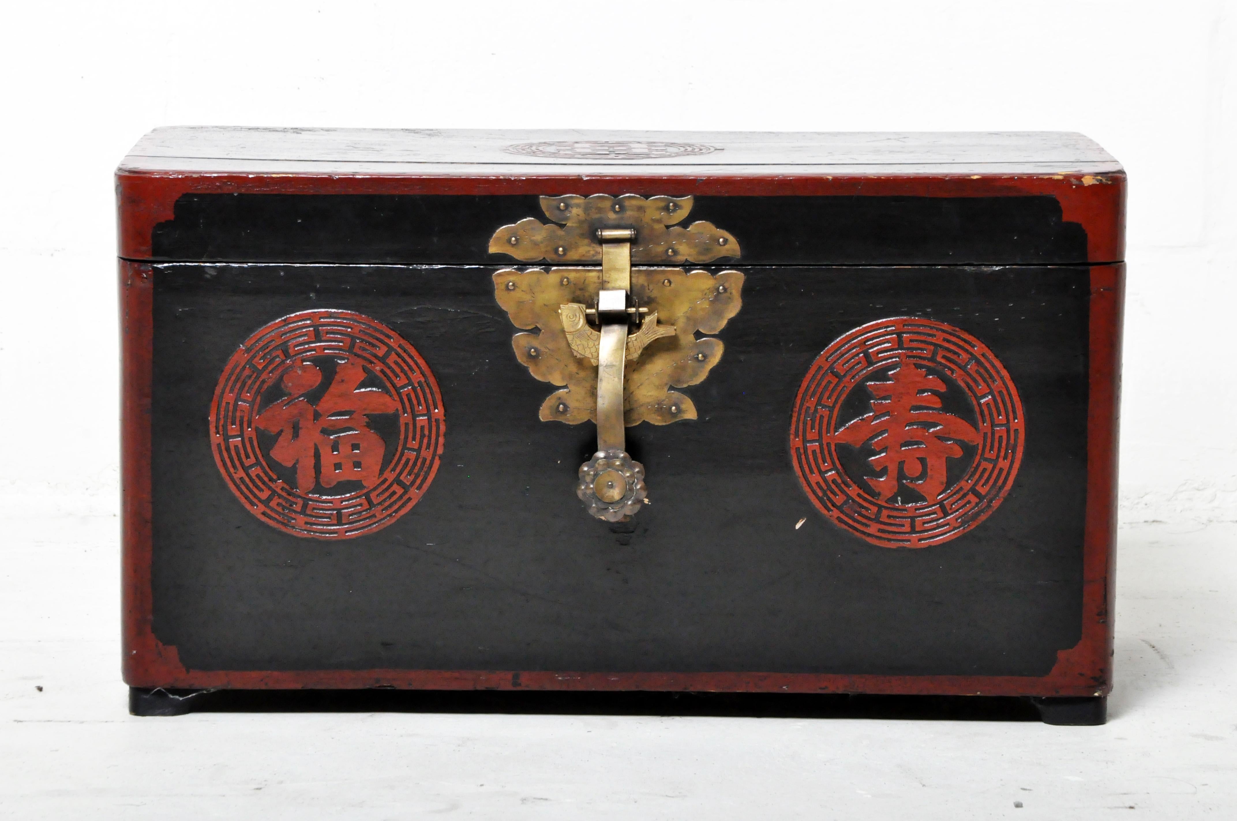 A Chinese storage chest with red and black lacquer over softwood. Used for seasonal clothing. Wear consistent with age and use. 
      