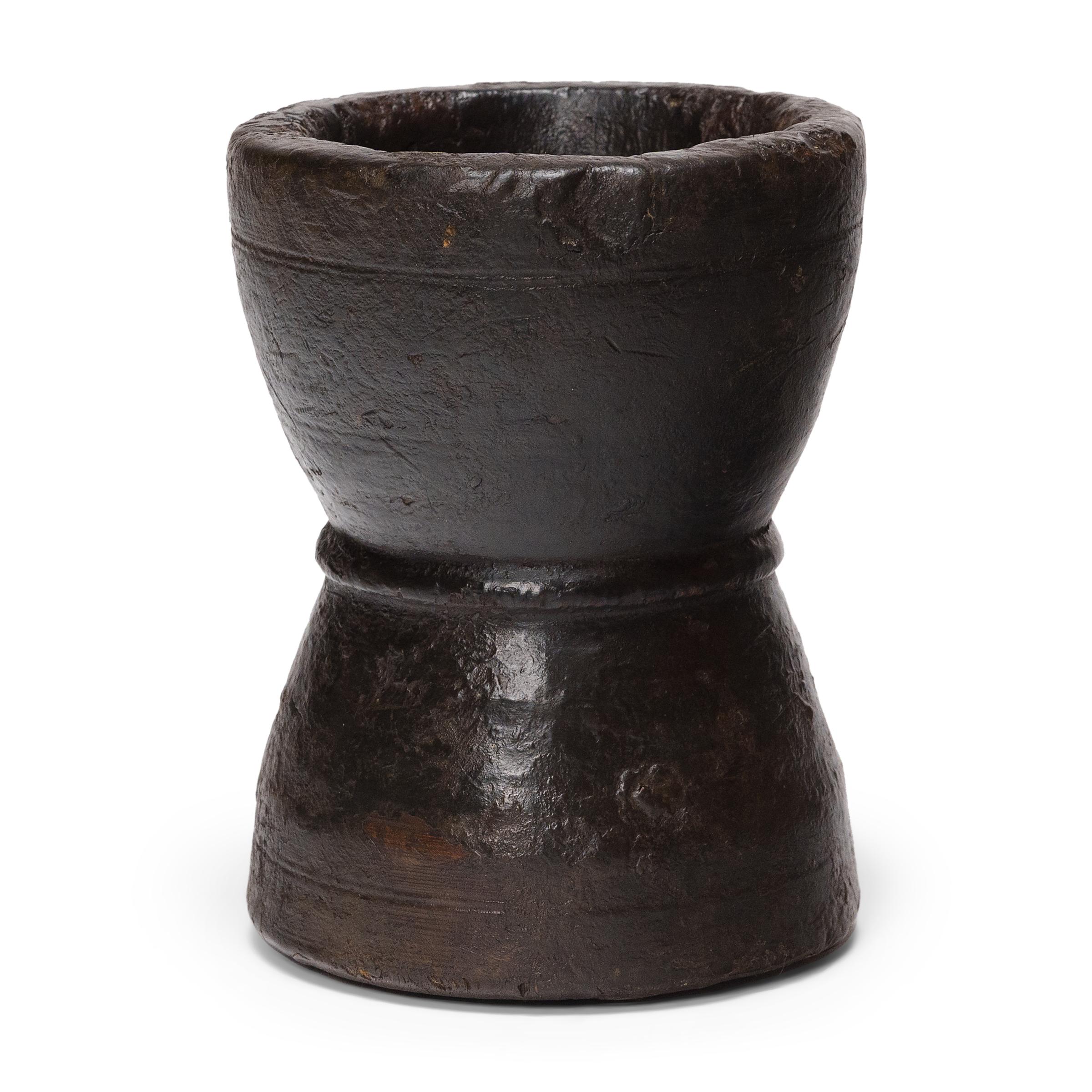 Questo piccolo recipiente in legno di pino è un mortaio dell'inizio del XX secolo, un tempo utilizzato quotidianamente in una cucina di provincia per macinare erbe, spezie e condimenti. Il contenitore rustico è stato tornito a mano a forma di