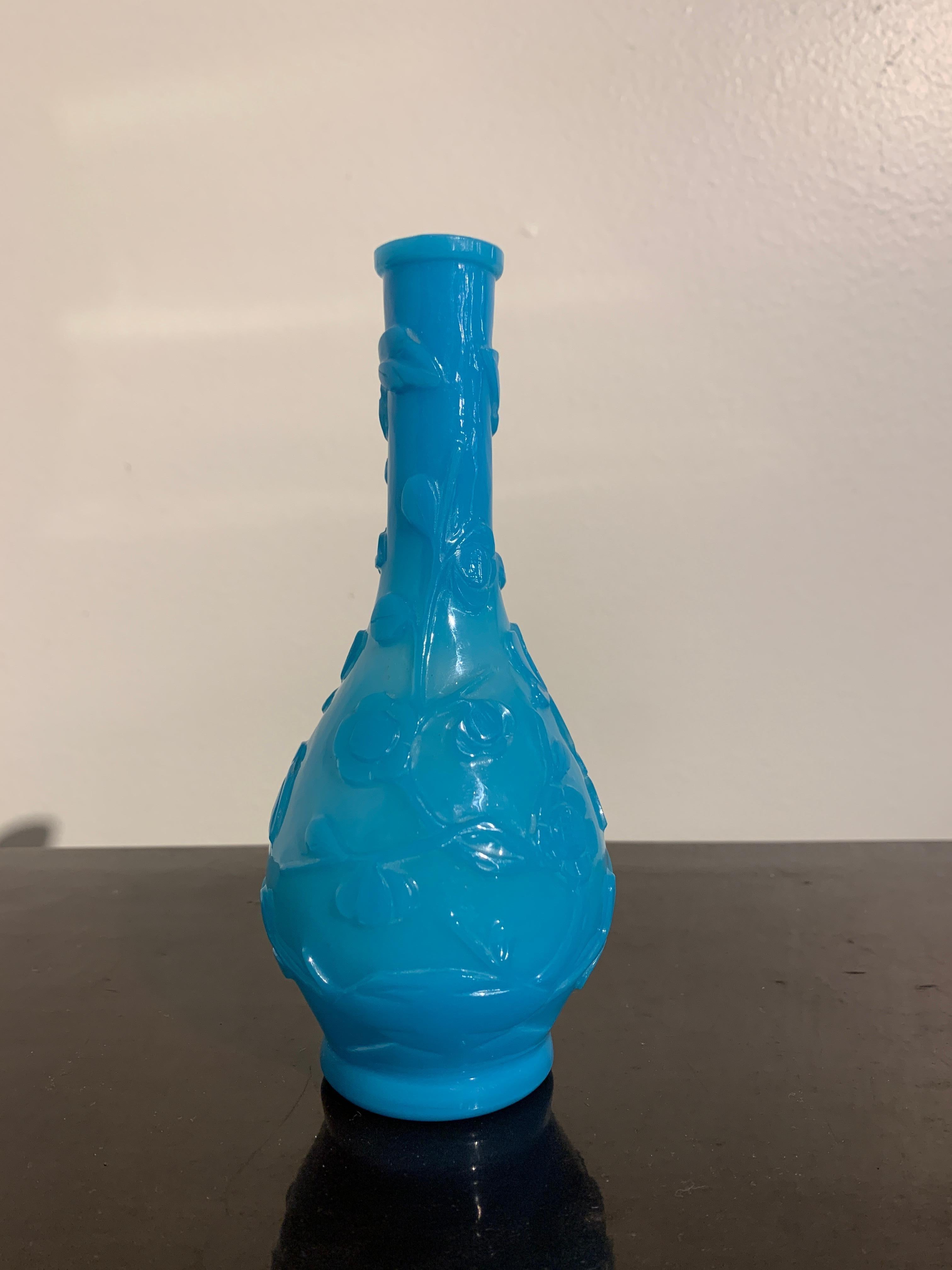 A small and charming turquoise blue carved Peking glass vase, Republic Period, early 20th century, China.

The Peking glass vase of elegant bottle shape featuring two shades of overlay blue. The outer layer of glass slightly darker than the inner