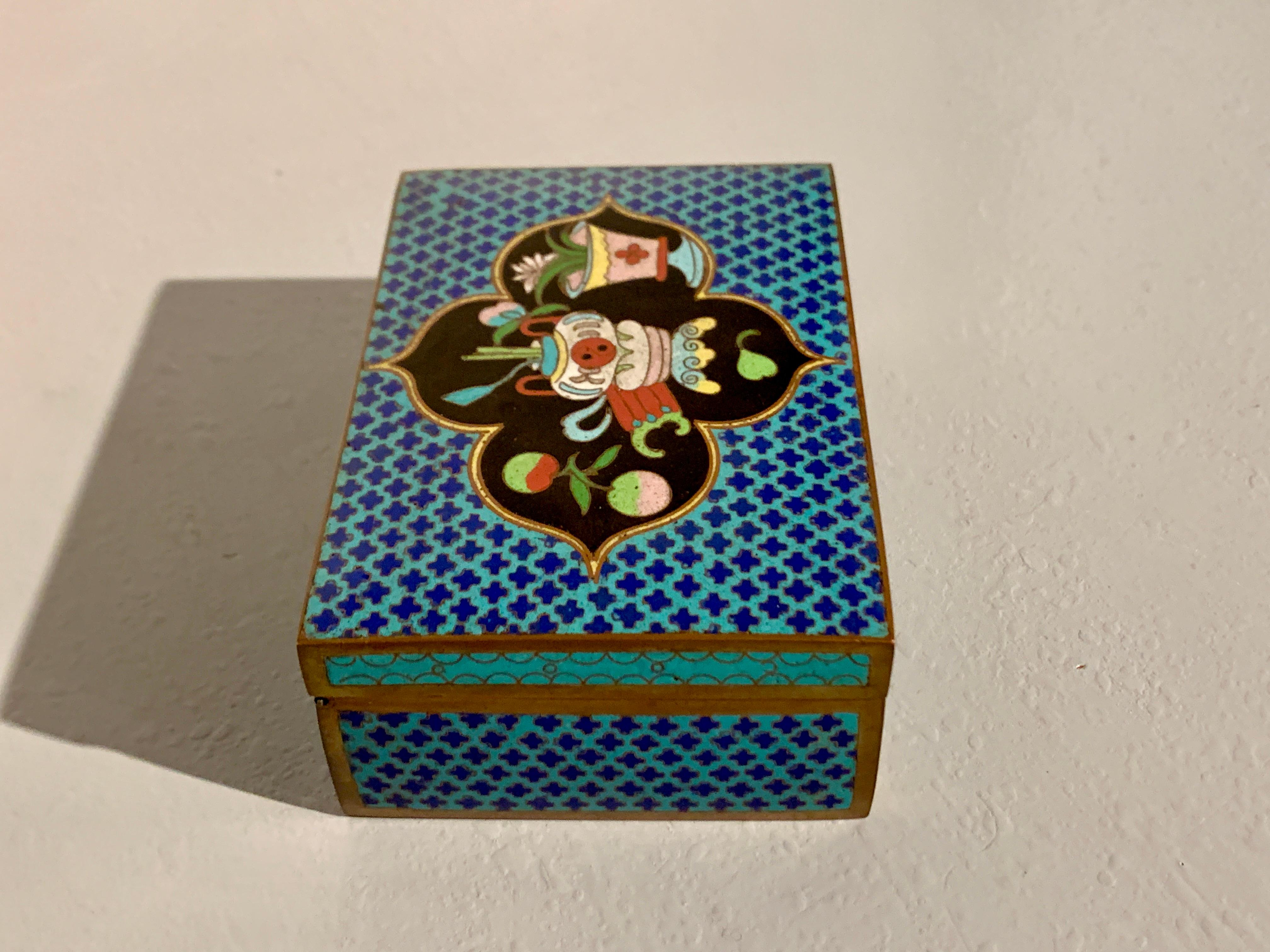 A lovely Chinese turquoise cloisonne trinket box with images of the Hundred Antiques, Republic Period, circa 1920, China.

The rectangular box decorated with a field of quatrefoils of lapis blue cloisonne against a turquoise blue cloisonne ground.