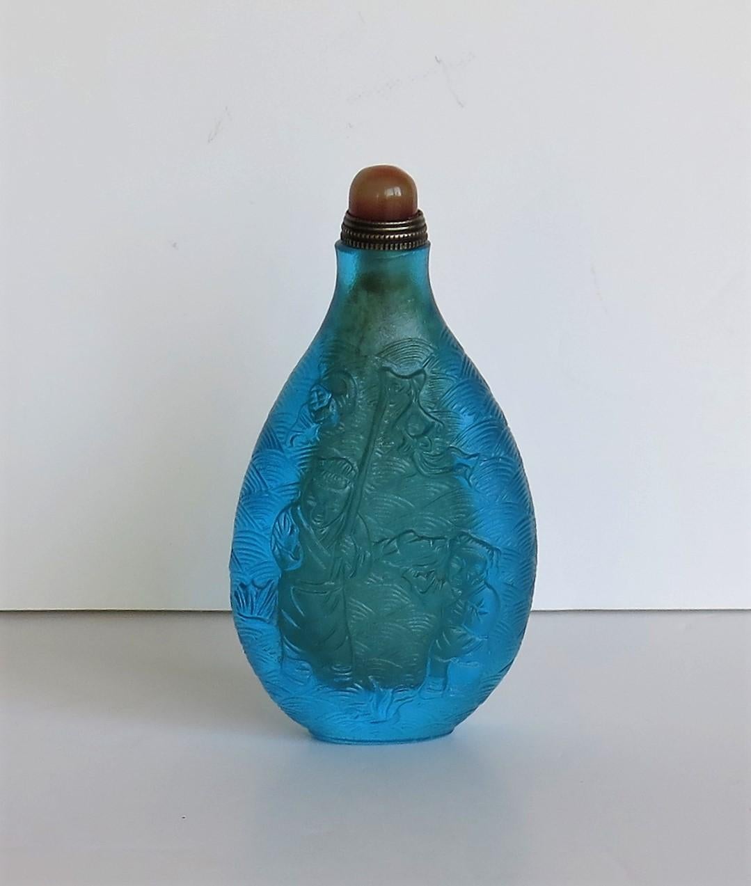 This is a very good Chinese glass snuff bottle, which we date to the mid-20th century, circa 1940s.

The snuff bottle is quite tall with a good tactile balluster shape. It is made of a distinctive turquoise (blue/green) coloured glass which has