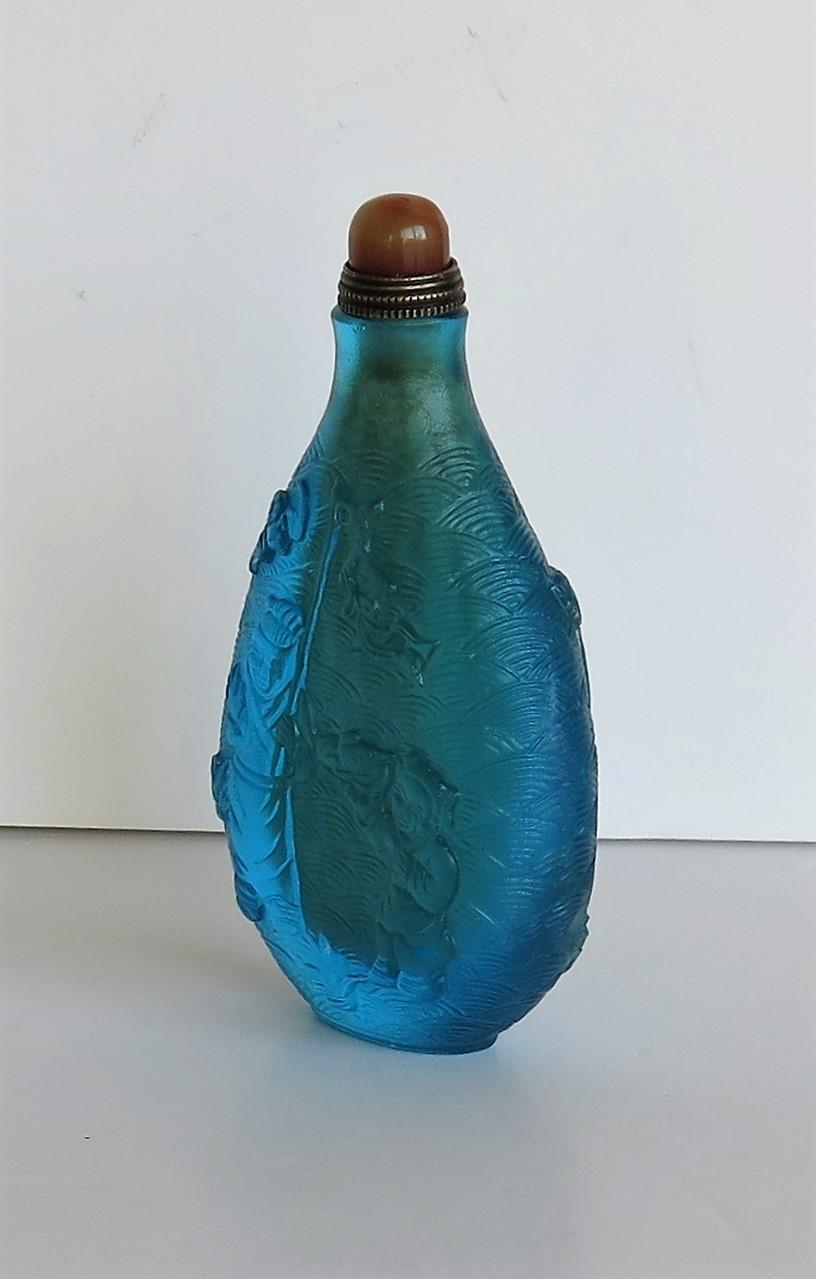 20th Century Chinese Turquoise Glass Snuff Bottle with Carved Figures and Spoon Top