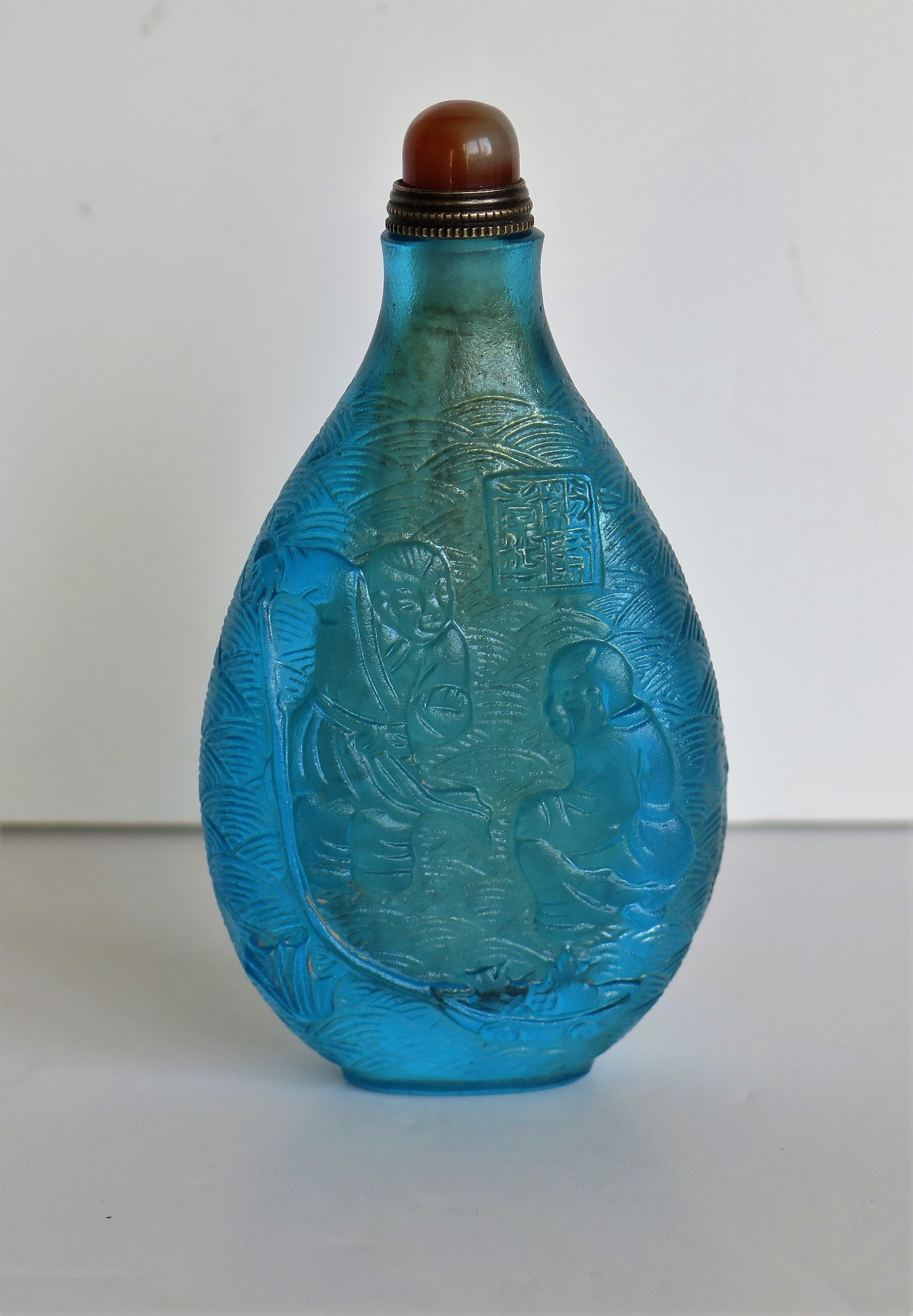 Chinese Turquoise Glass Snuff Bottle with Carved Figures and Spoon Top 1