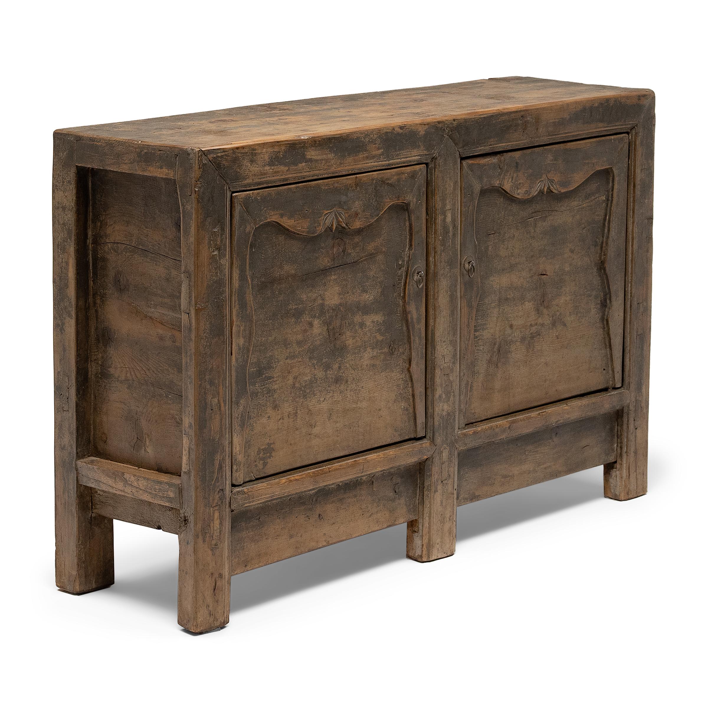 This late 19th-century storage coffer balances a streamlined silhouette with textured, wabi-sabi materials. Created in the style of Mongolian trunks, the two-door sideboard was originally configured to open from the top and has been modified with