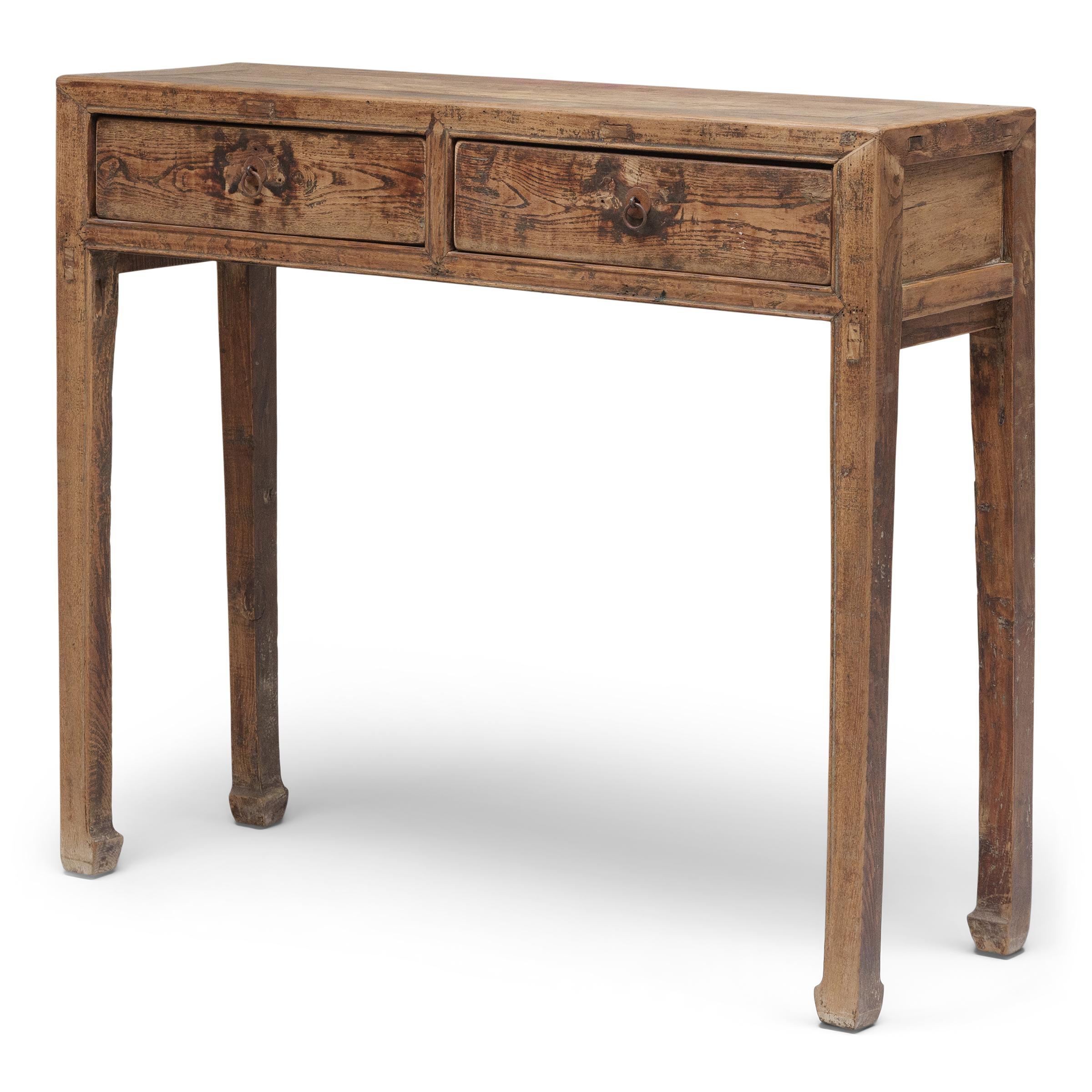This clean-lined console table dates to the late 19th century and was likely used as a small offering table or as a dressing stand in the women's quarters of a Qing-dynasty home. The narrow table has a simple silhouette, designed with a rectangular