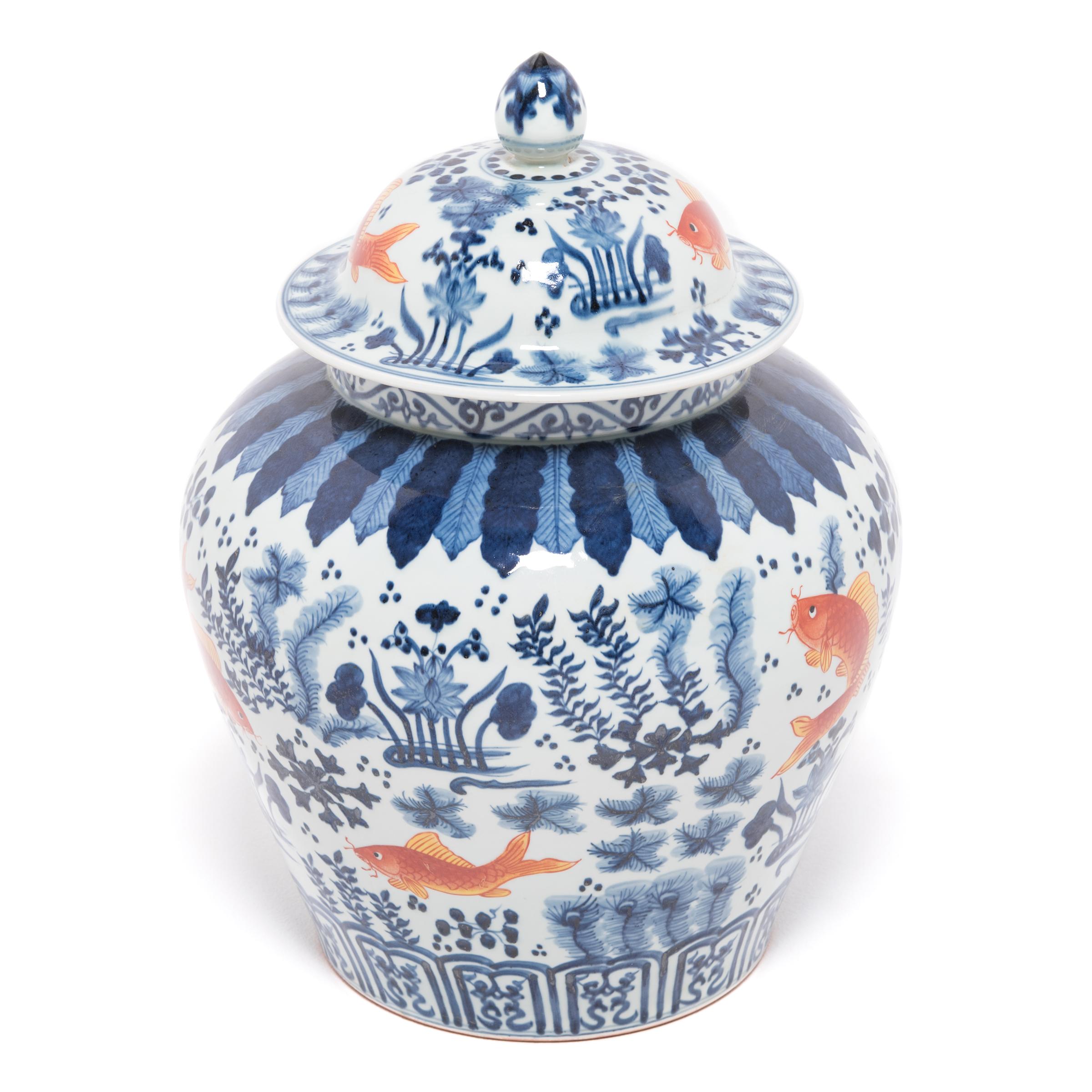 A modern artisan applied the vibrant copper and indigo imagery before firing, a process of under glazing that was developed during the Song dynasty. The finely painted symbols, fish, lotus pods, and underwater plants hold deeper meaning in Chinese
