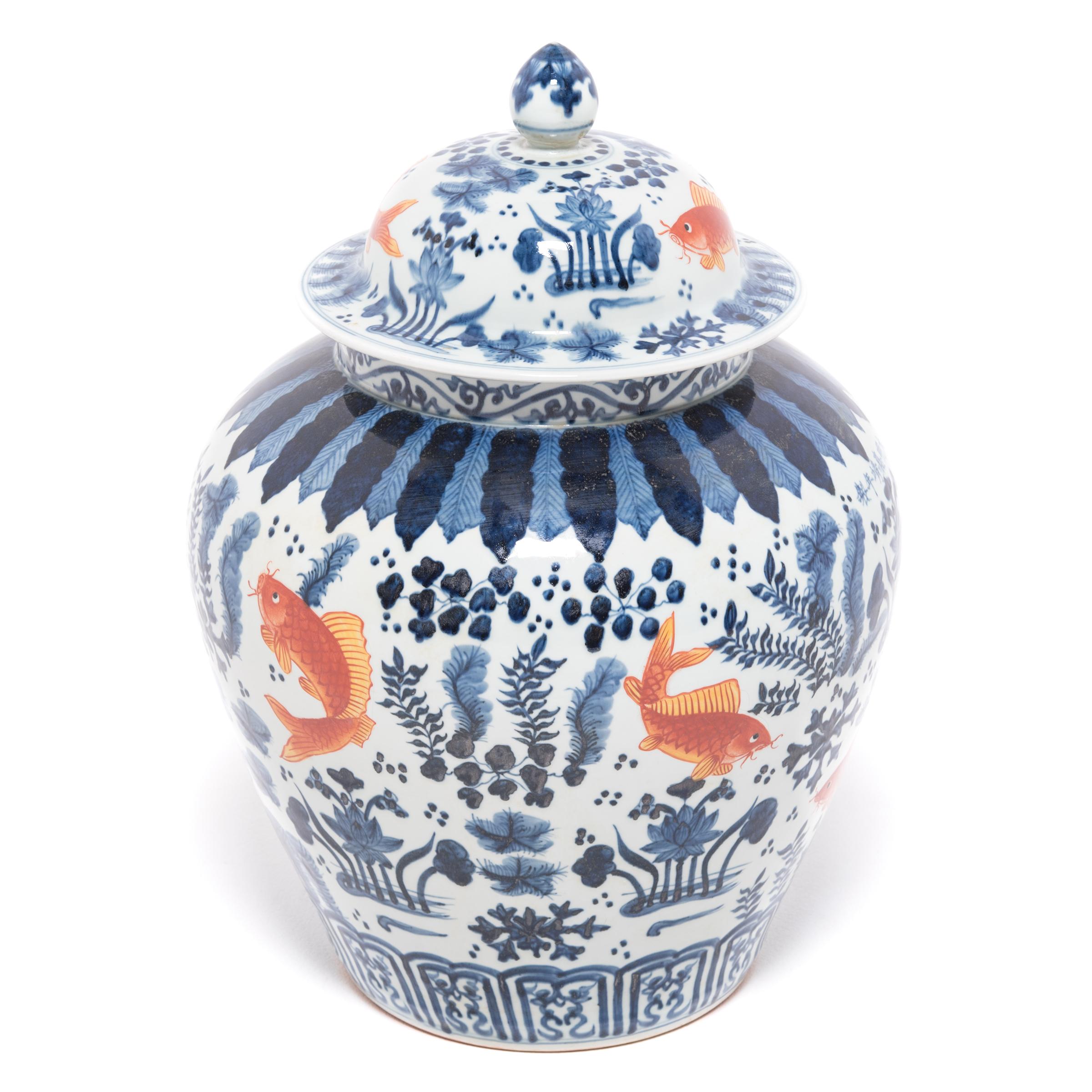 A modern artisan applied the vibrant copper and indigo imagery before firing, a process of under glazing that was developed during the Song dynasty. The finely painted symbols, fish, lotus pods, and underwater plants hold deeper meaning in Chinese