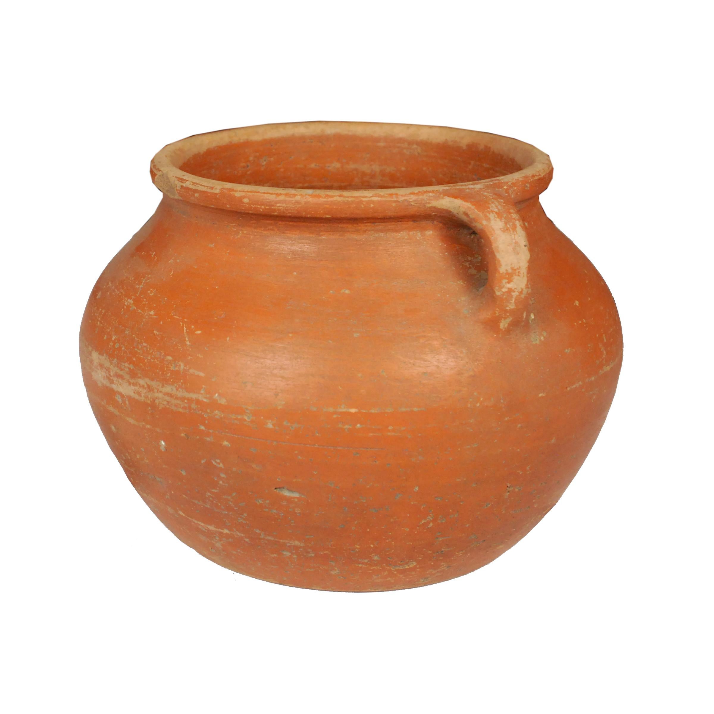 Based on prototypes fired in ancient Chinese kilns, this jar's perfect proportions haven't changed much since the Bronze Age. Keeping in the tradition of its predecessors, this early 20th century ceramic vessel is glazed with a slip of red clay,