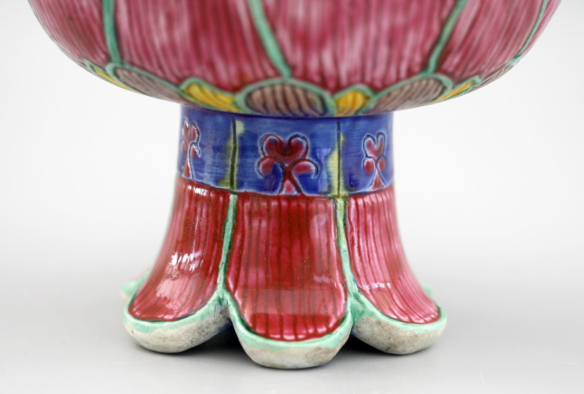 A very unusual antique Chinese porcelain pedestal lotus flower shaped bowl hand painted in bold solid colors believed to date from the early 20th century or possibly earlier. The lotus flower shaped bowl stands raised on a leaf shaped base the
