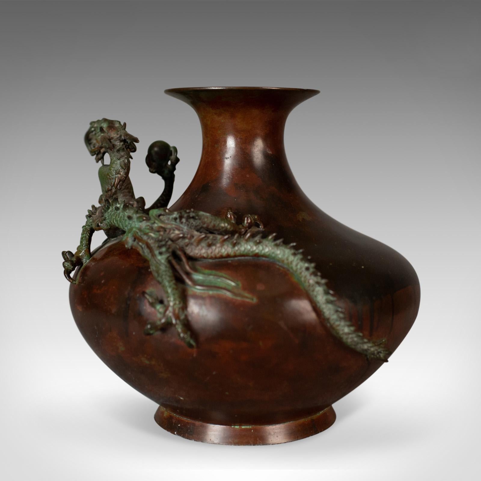 This is a Chinese urn or vase in bronze with a dragon and pearl mounted to the bowl a 20th century oriental centrepiece.

Superbly detailed bronze lithe dragon and pearl
The dragon displaying well in multiple hues
Mounted to the bowl of the urn