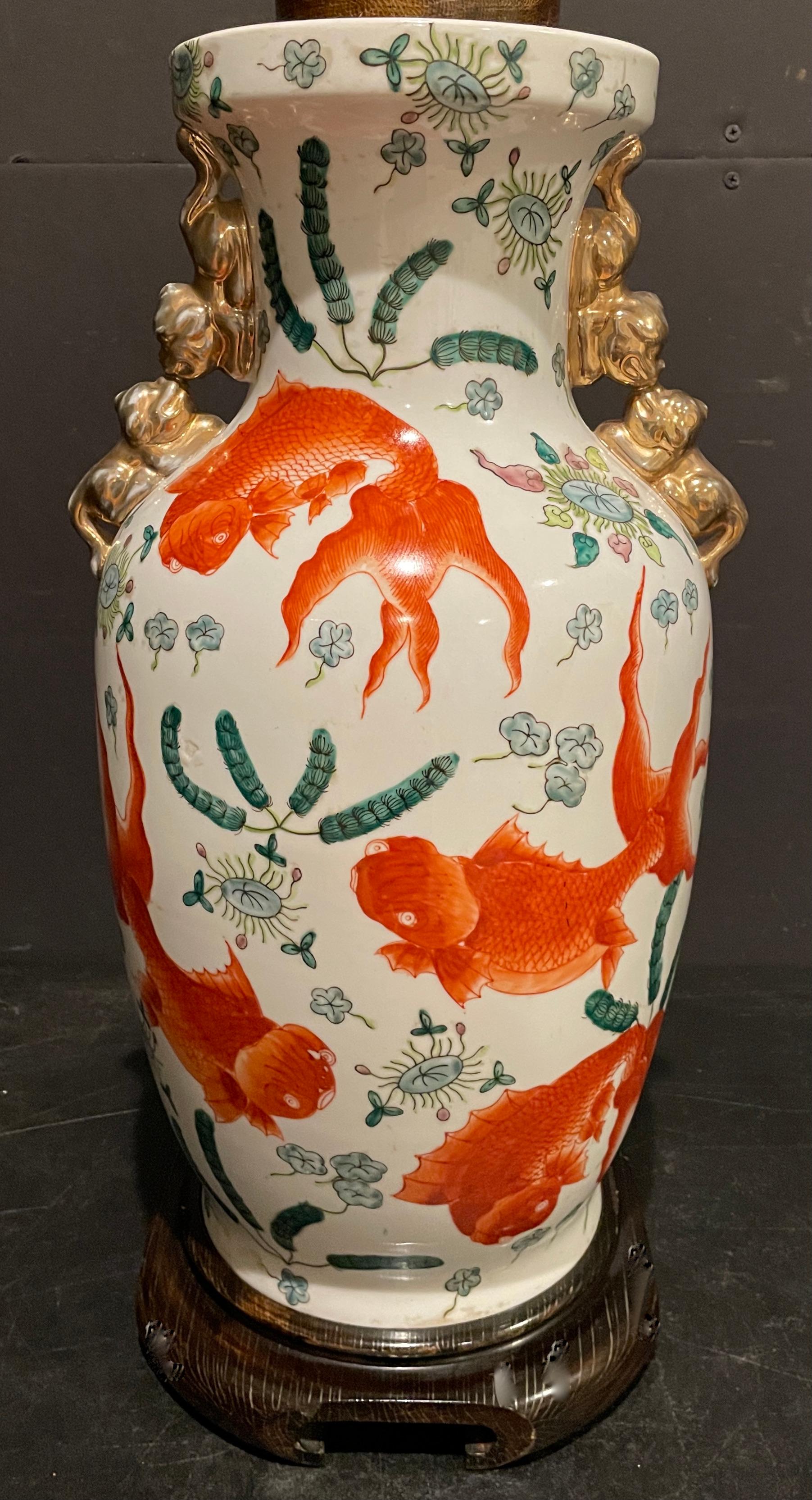 Orange and white vase as lamp, featuring Koi fish amongst seaweed. Applied gilt Foo Dog handles. Colorful famille rose images.
20
