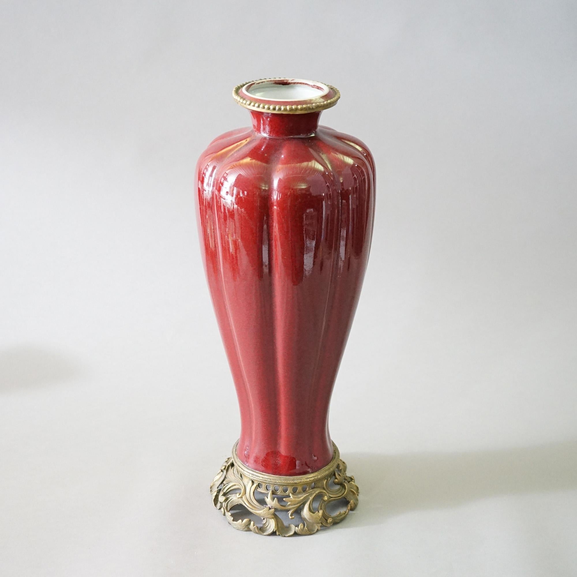 A Chinese porcelain vase offers porcelain construction in vermillion red glaze with foliate cast bronze mounts, 20th century

Measures- 20.75''H x 7.75''W x 7.75''D.

Catalogue Note: Ask about DISCOUNTED DELIVERY RATES available to most regions