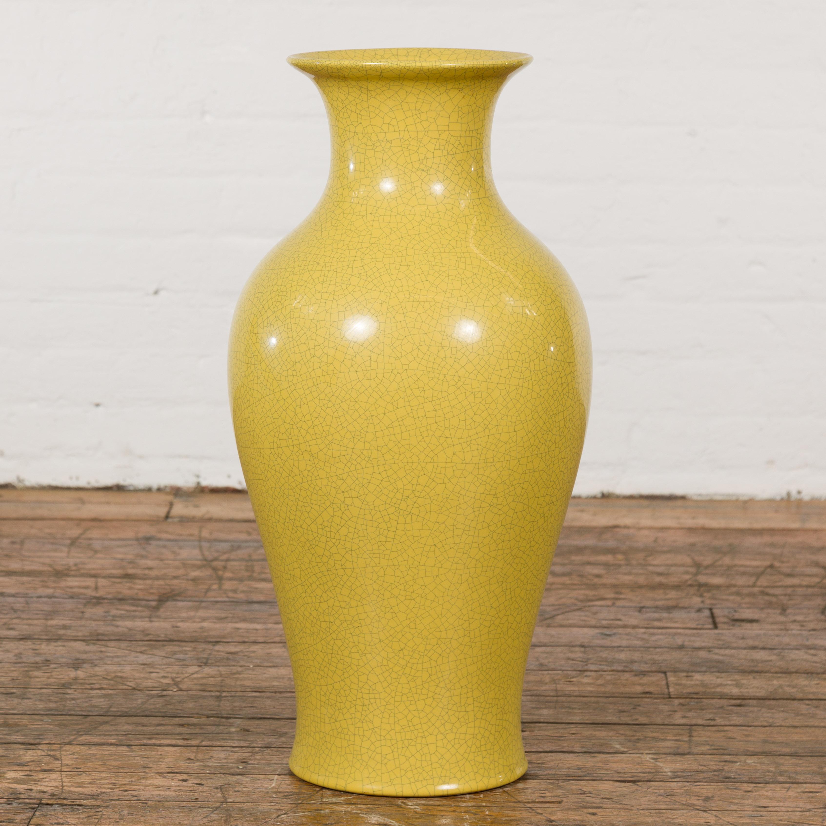 A Chinese vintage altar vase from the mid 20th century, with yellow crackle finish and flaring neck. Immerse yourself in the rich tradition of Chinese artistry with this captivating vintage altar vase. Dating back to the mid-20th century, this piece