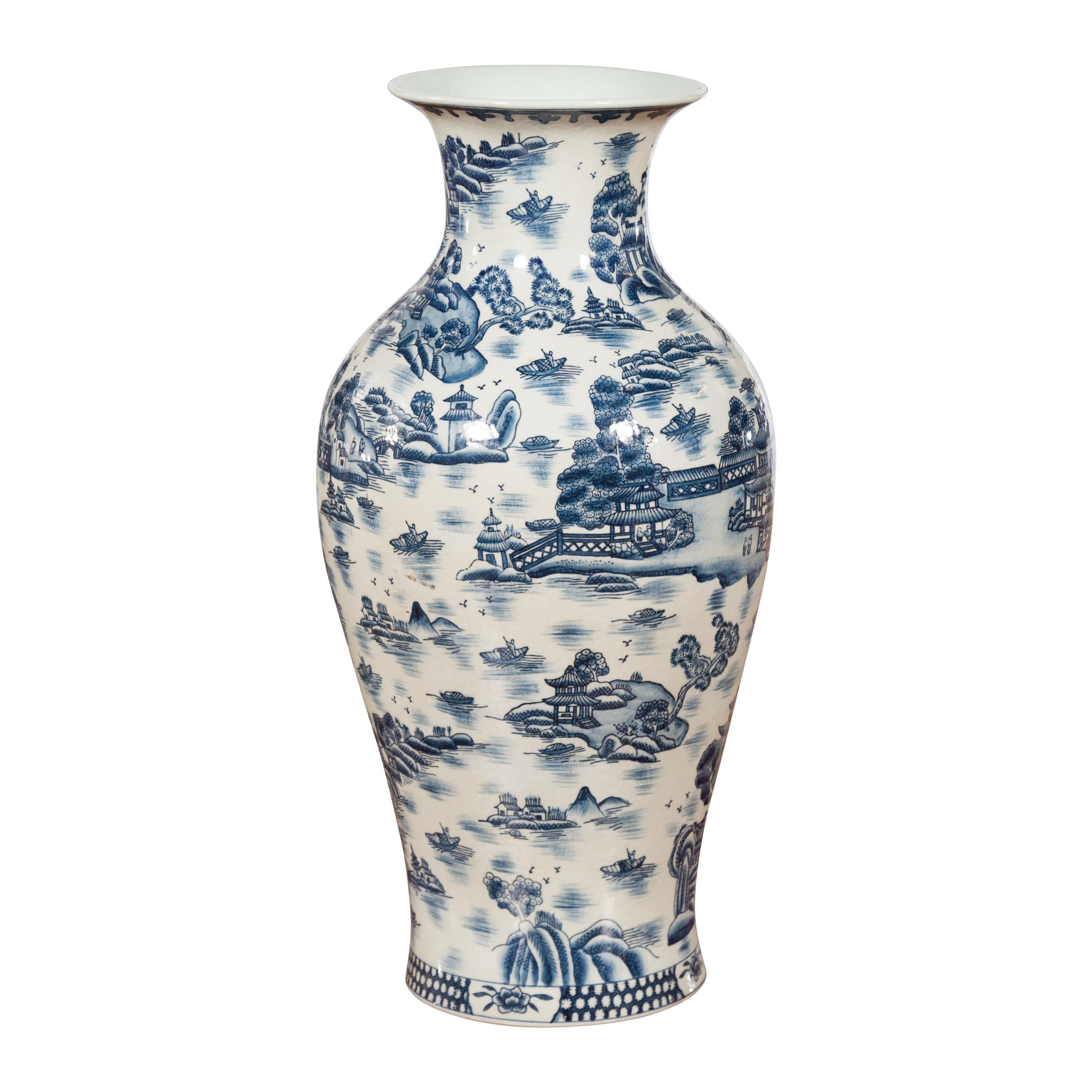 A vintage Chinese porcelain vase from the mid 20th century, with hand-painted blue and white body. Created in China during the midcentury period, this porcelain vase features a nicely curving silhouette topped with a narrow neck and a splaying