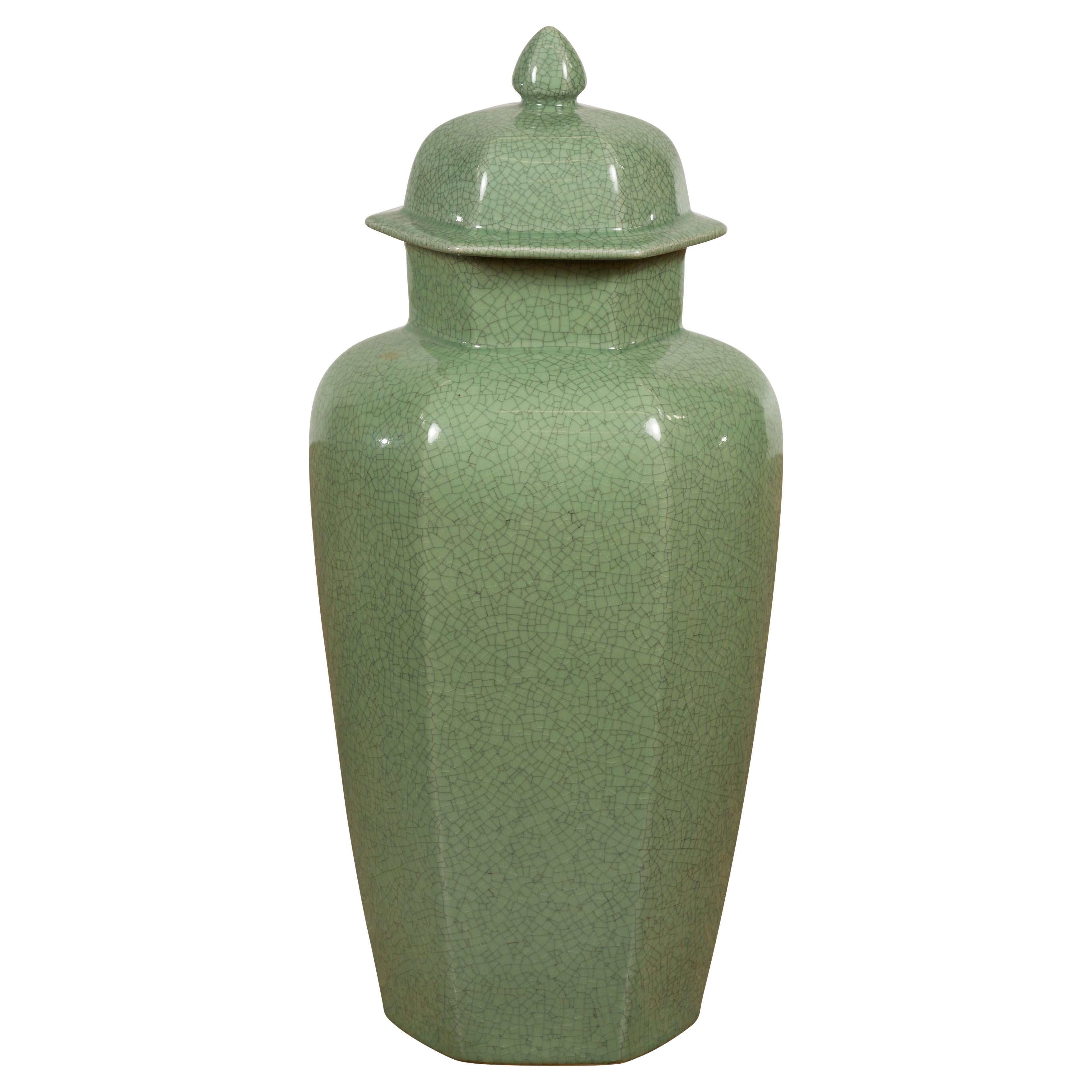 A vintage Chinese celadon color altar vase with hexagonal lid, bud top, tapering lines and elegant crackle design. This vintage Chinese altar vase evokes a sense of serene elegance with its soft celadon color and distinctive crackle design.